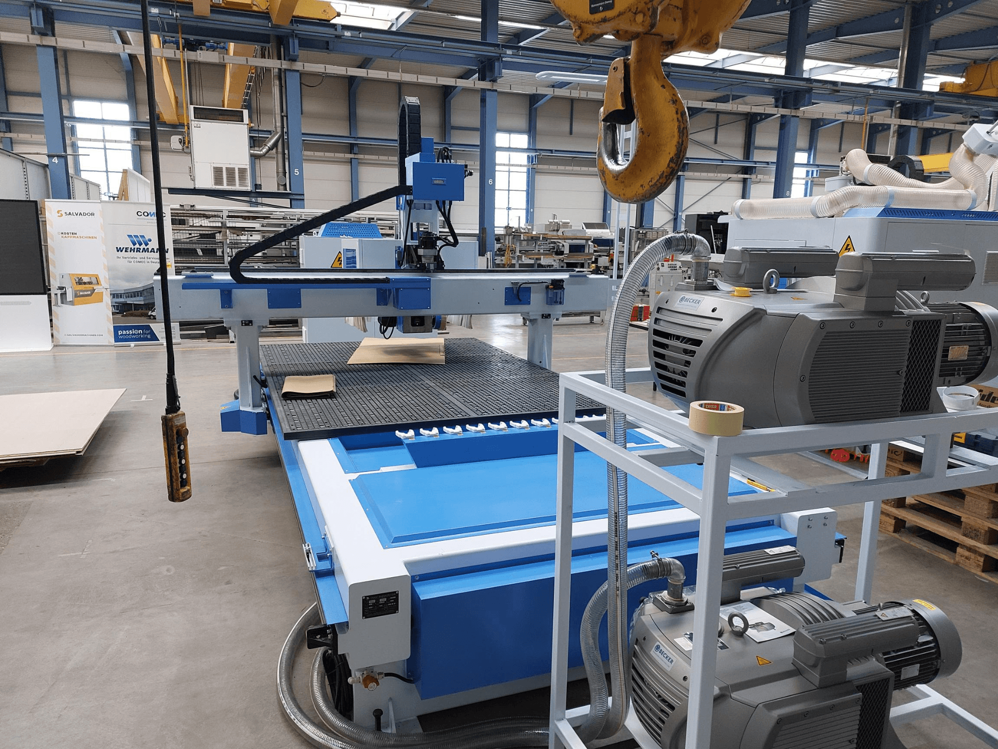 CNC kokapstrādes centrs QUICK CNC UA 481, skats no priekšpuses, kurā redzams vadības panelis, motori un darba virsma ar koka detaļu.