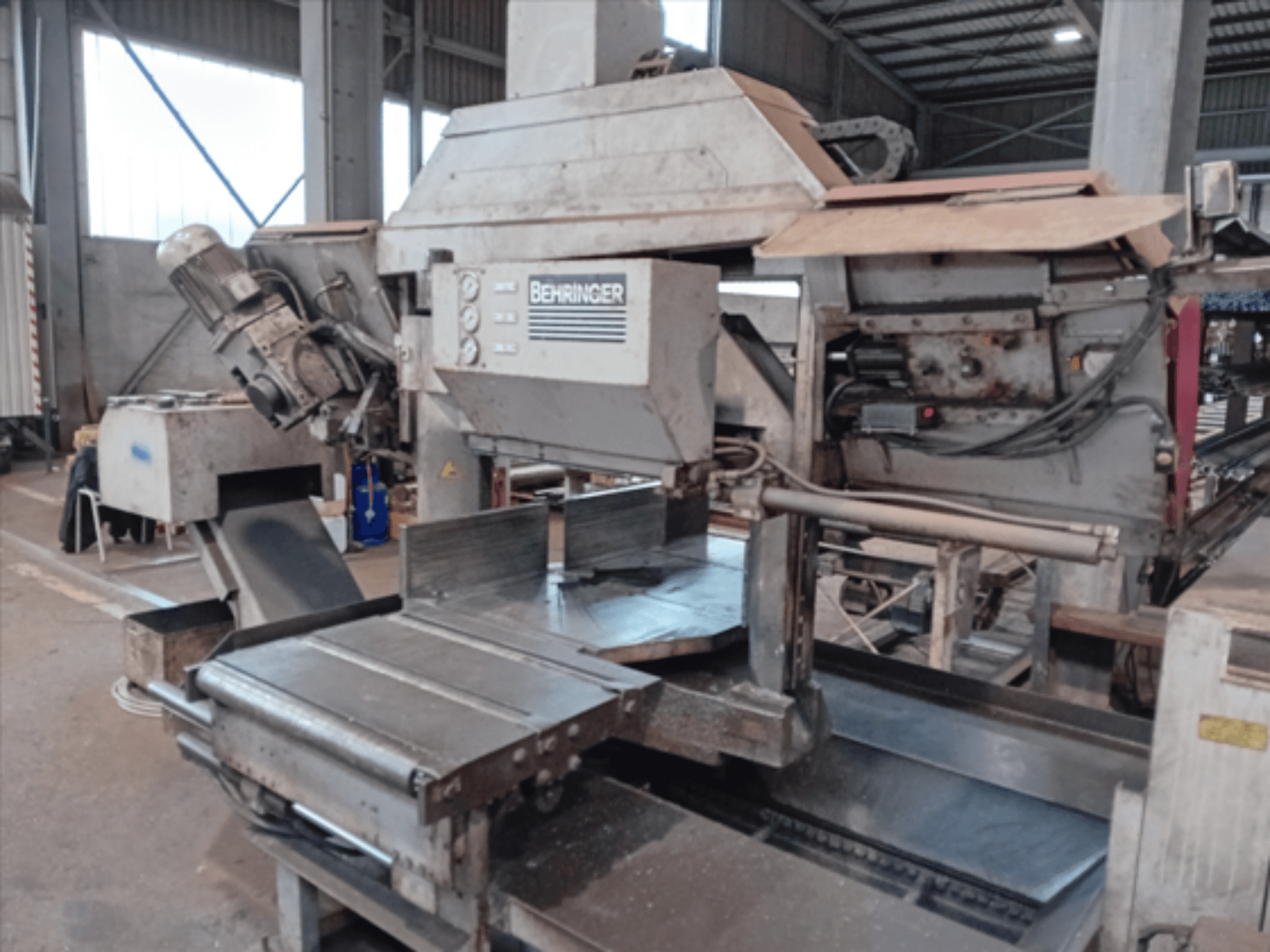 Behringer lentzāģis, skats no priekšpuses, ar lielu asmeni, motoru un regulējamu galdu, ideāli piemērots metāla griešanai darbnīcā.