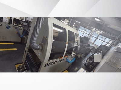 DECO 2000 CNC darbnīcā, skats no priekšpuses, ar ventilācijas šļūteni un vadības paneli, paredzēts precīzai apstrādei.