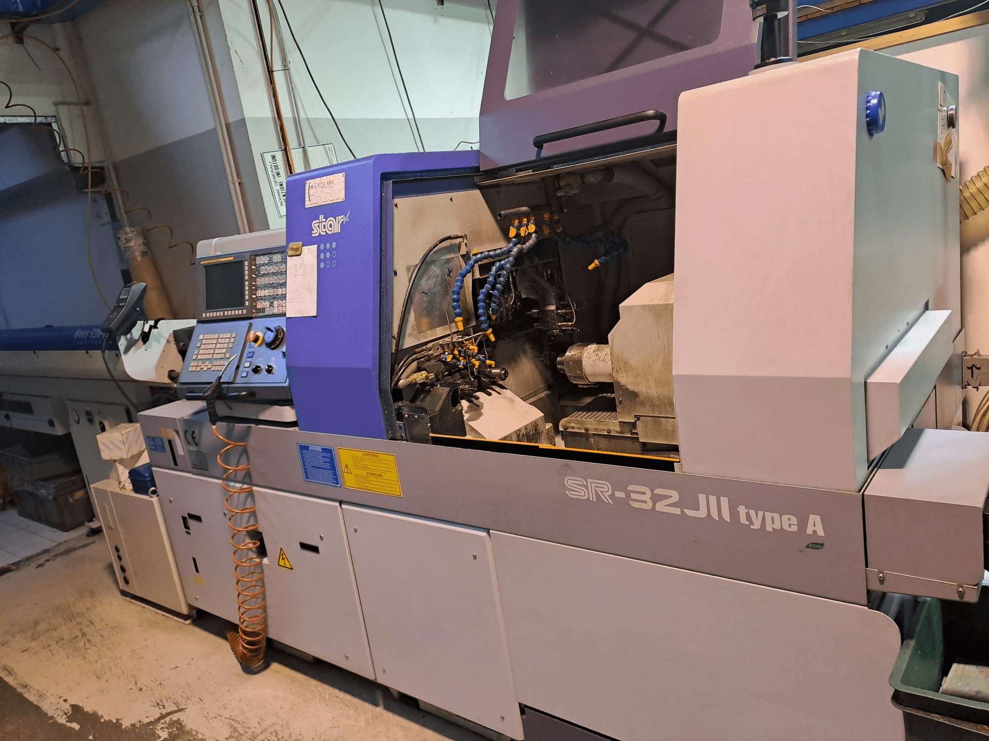 STAR MICRONICS SR-32JII-typeA Šveices tipa virpošanas darbgalds skats no sāniem, ar vadības paneli un redzamām apstrādes sastāvdaļām.