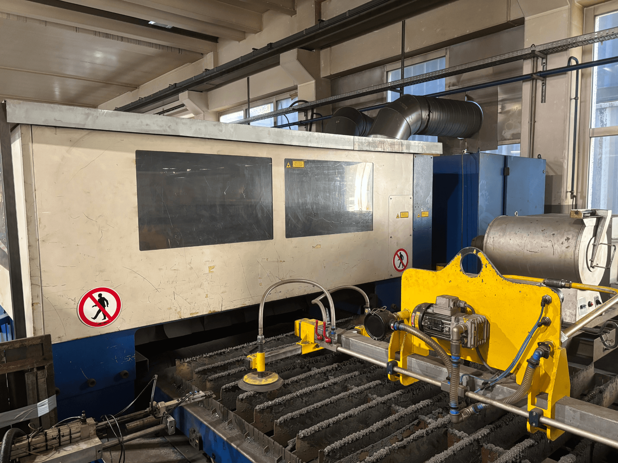 TRUMPF Trumatic L3030 CO2 lāzera griešanas iekārta, priekšējais skats, kurā redzams vadības interfeiss un griešanas virsmas detaļas.