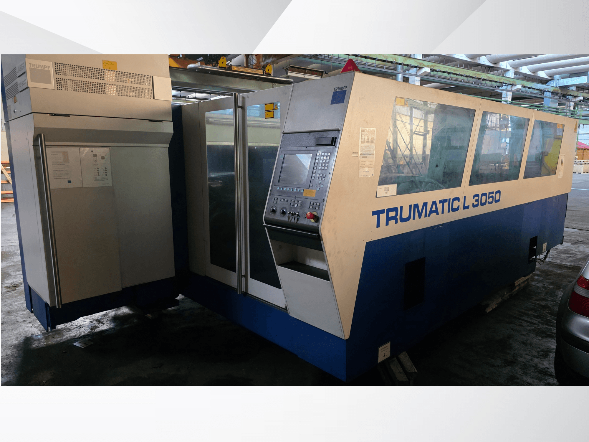 TRUMPF Trumatic L 3050 CO2 lāzera griešanas iekārta, skats no priekšpuses, ar vadības paneli un lieliem stikla logiem.