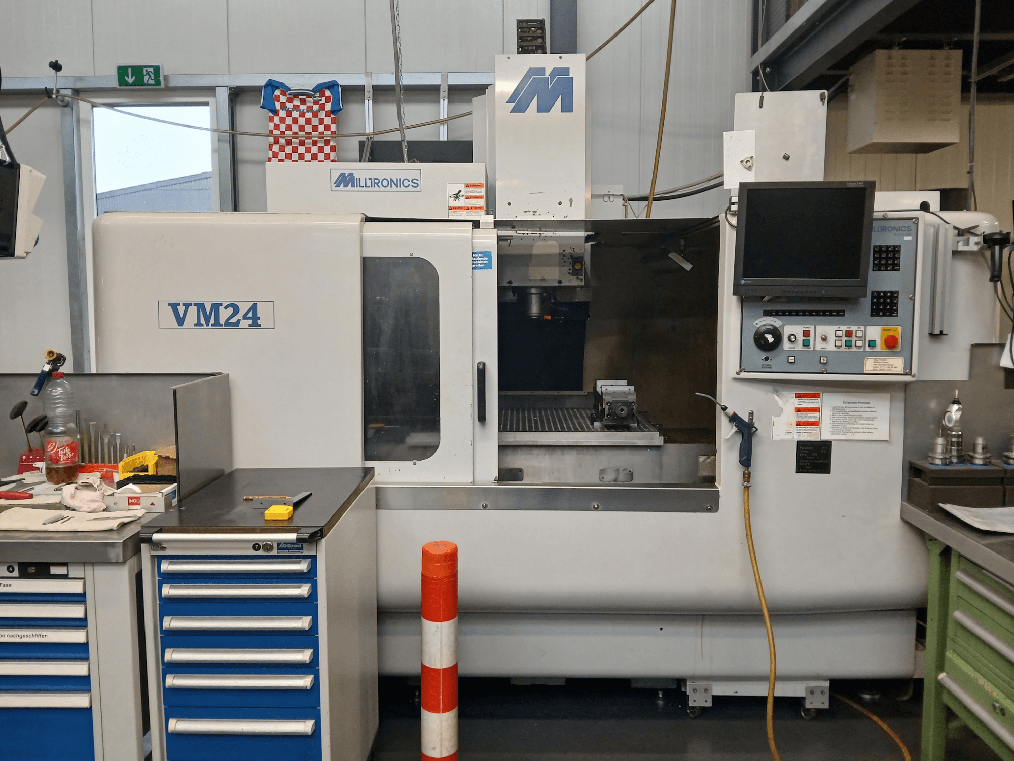 Milltronics VM24 CNC frēzmašīna no priekšpuses, ar vadības paneli, instrumentu glabāšanas vietu un darba zonas iestatījumiem.