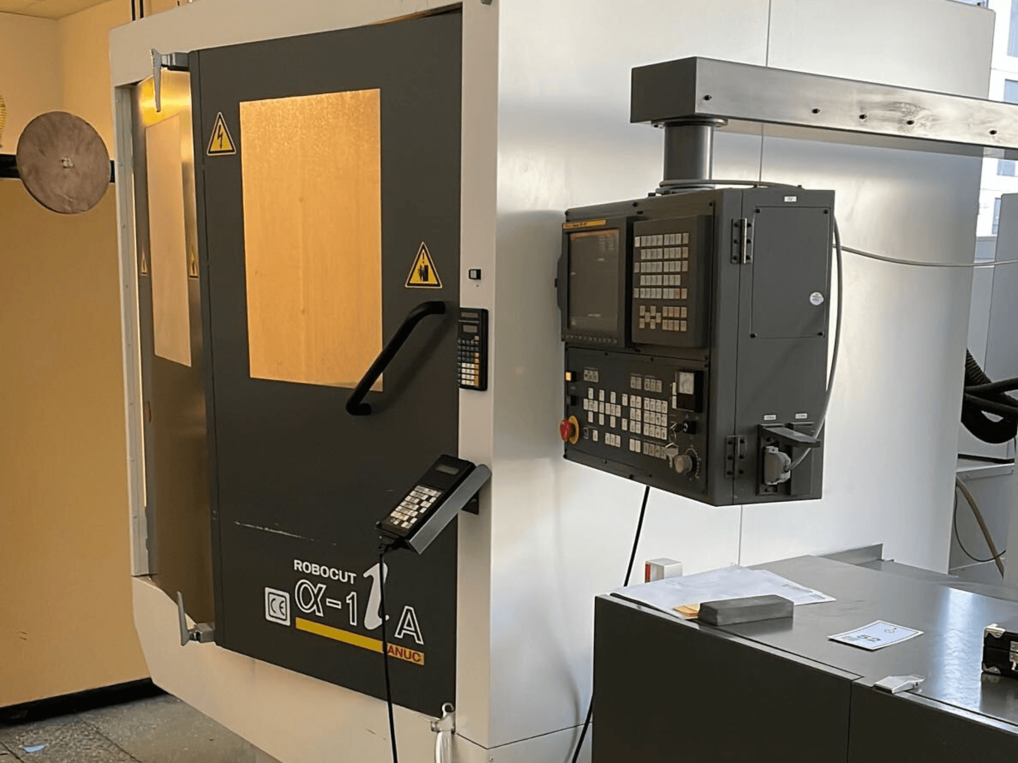 Robocut CX-1 Mašīna ar vadības paneli; priekšējais skats, kurā redzamas drošības durvis un vadības saskarne.