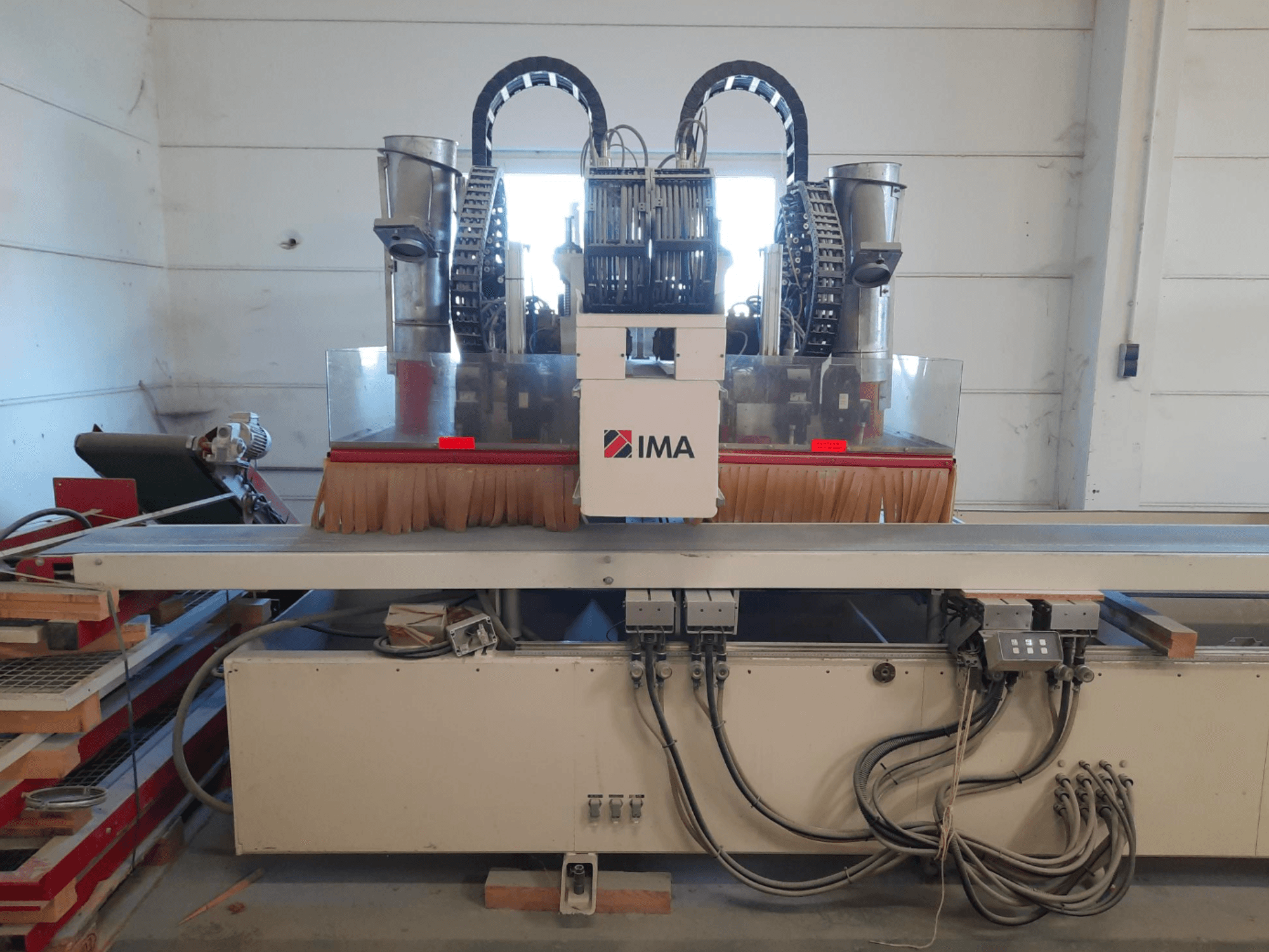 CNC koka apstrādes centrs IMA BIMA 610 V, redzams no priekšpuses, ar suvām, vadības elementiem un darba galdu.