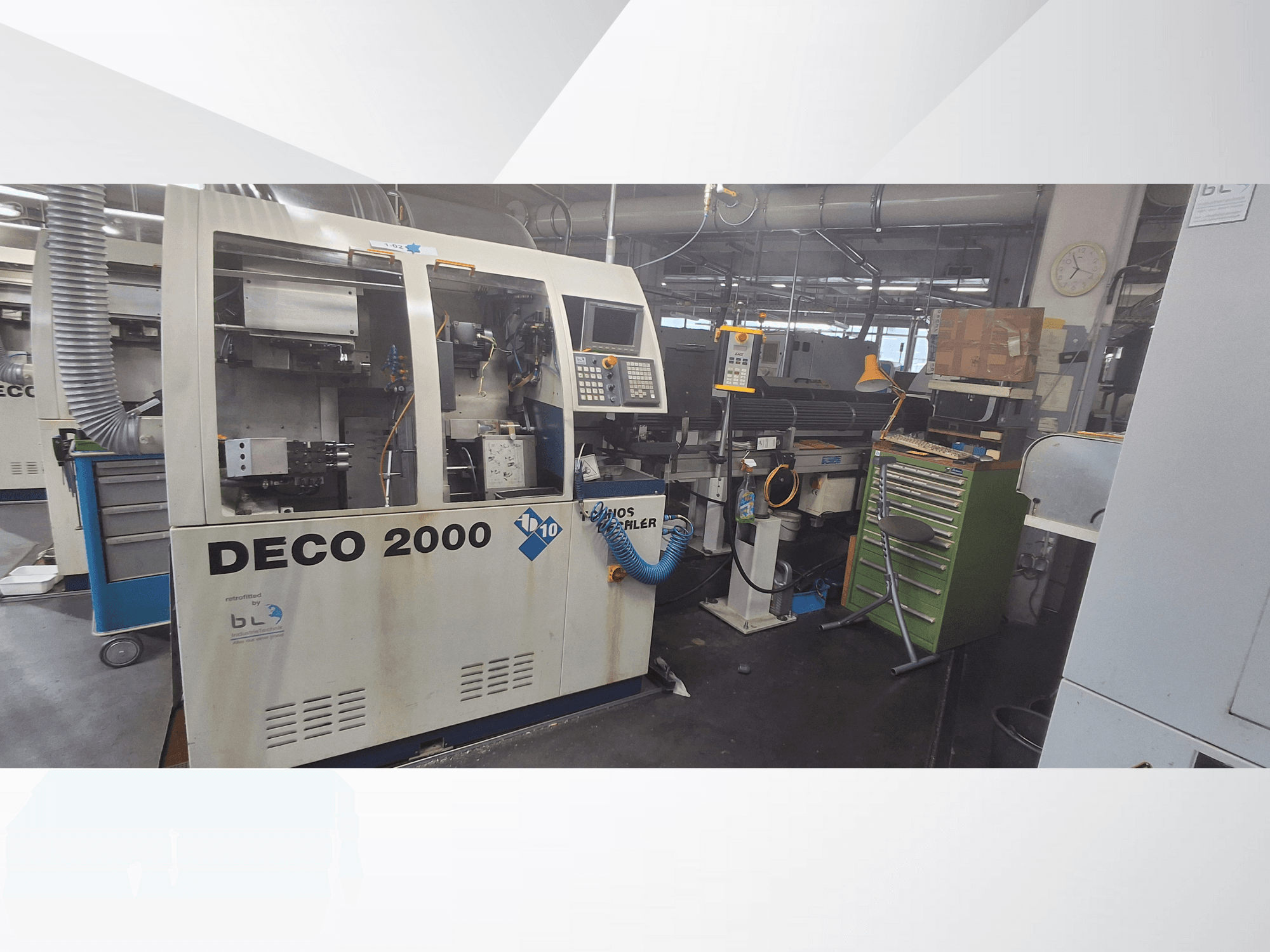 DECO 2000 iekārta, skatoties no priekšpuses, ar vadības paneli, caurulēm un pārblīvētu darba vietu ar instrumentiem un kastēm.