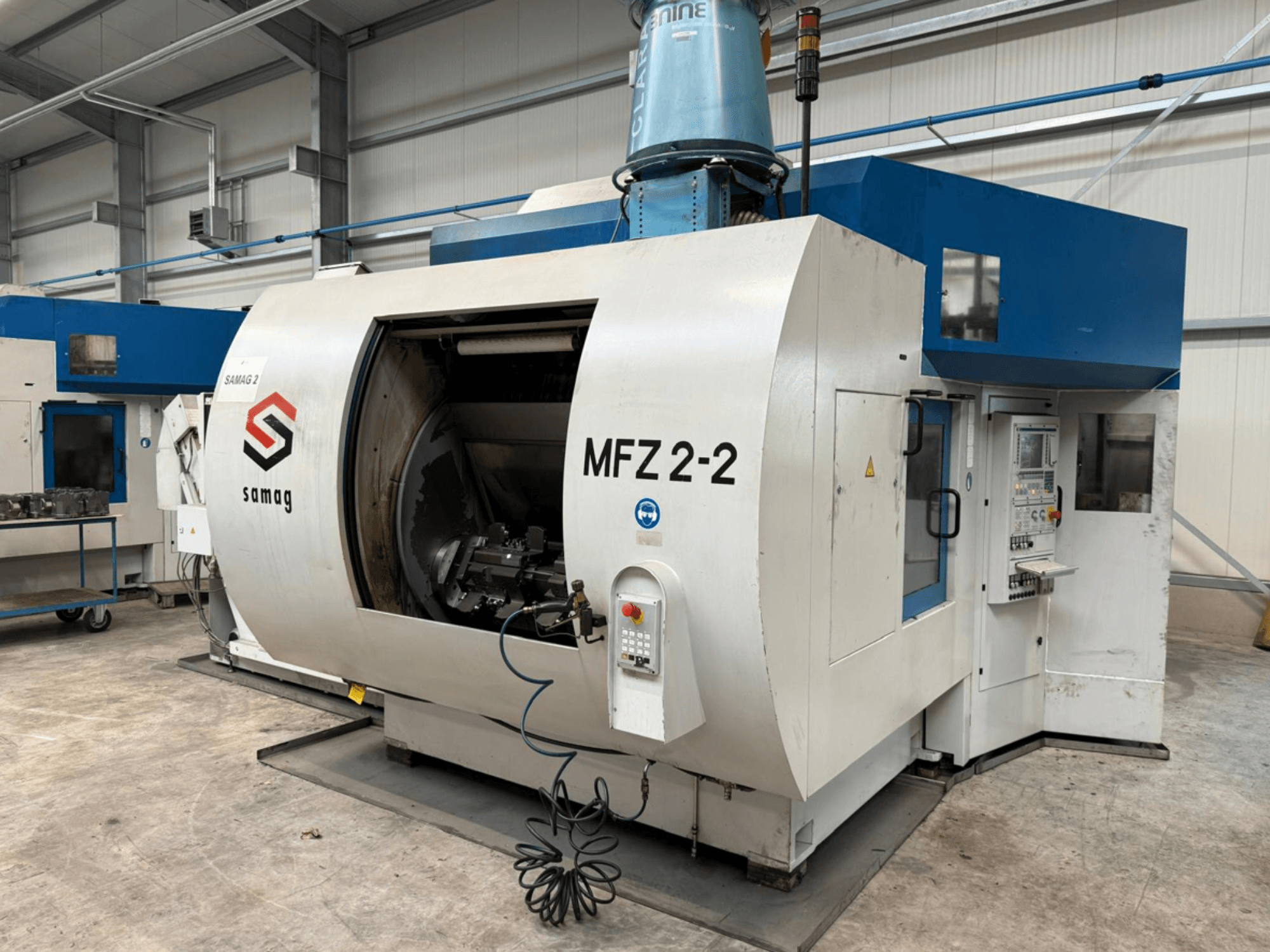 Samag MFZ 2-2 frēzmašīna sānu skatā, kurā redzama liela, atvērta kamera un vadības panelis ar dažādām pogām un slēdžiem.