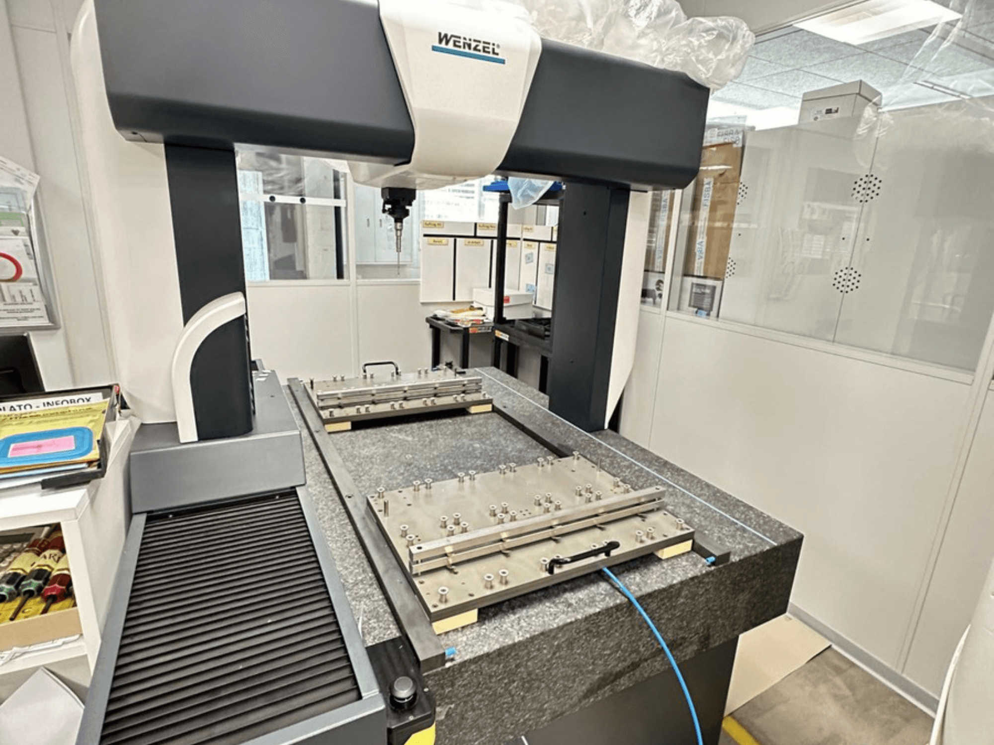 Wenzel LH 65 CMM laboratorijas apstākļos, kur redzams granīta pamatne ar regulējamu mērīšanas platformu un virsgalvas roku.
