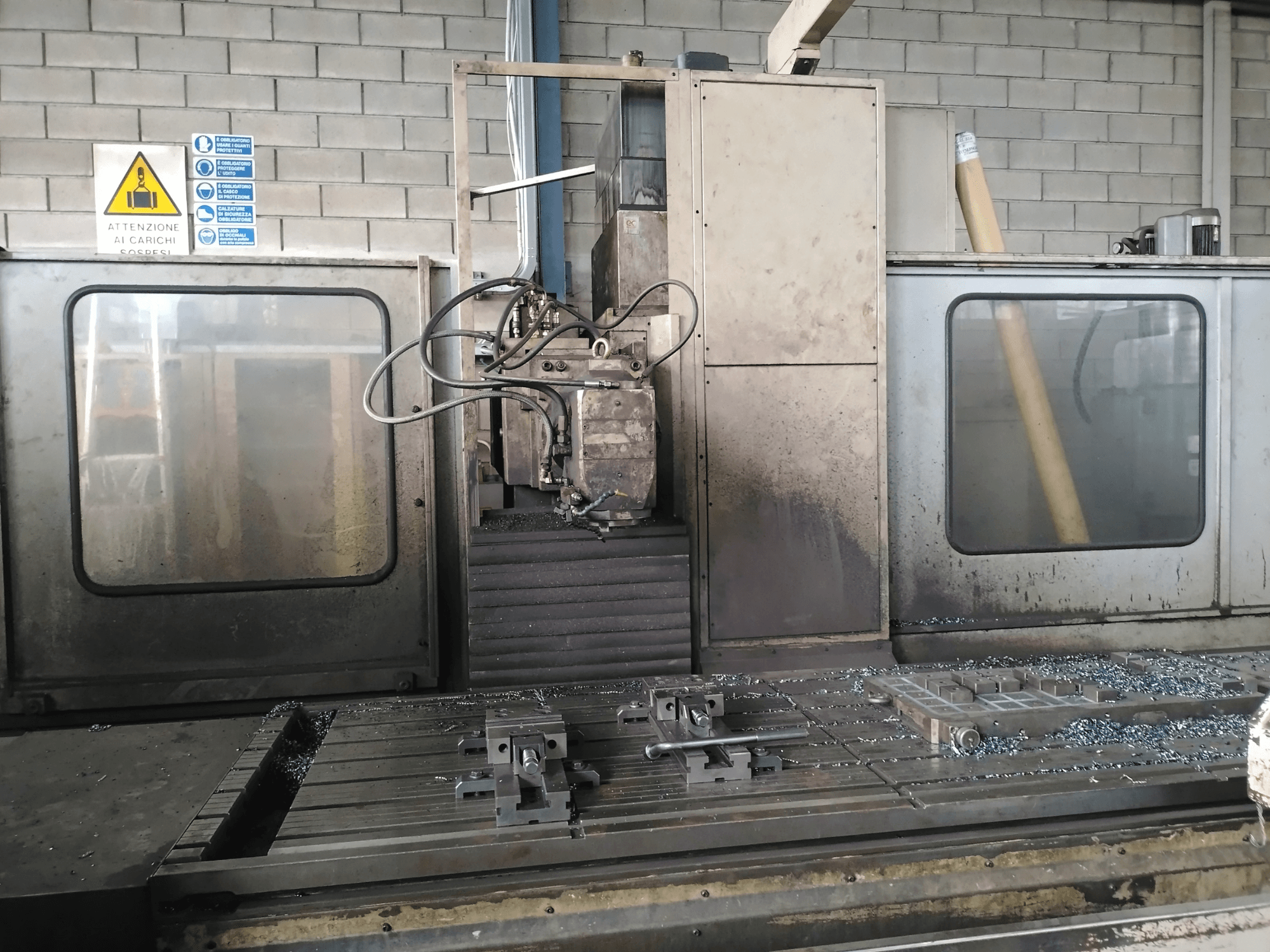 TIGER TFA6 gultas tipa frēzmašīna darbnīcā, priekšējais skats, kurā redzami instrumenti un metāla skaidas uz galda.