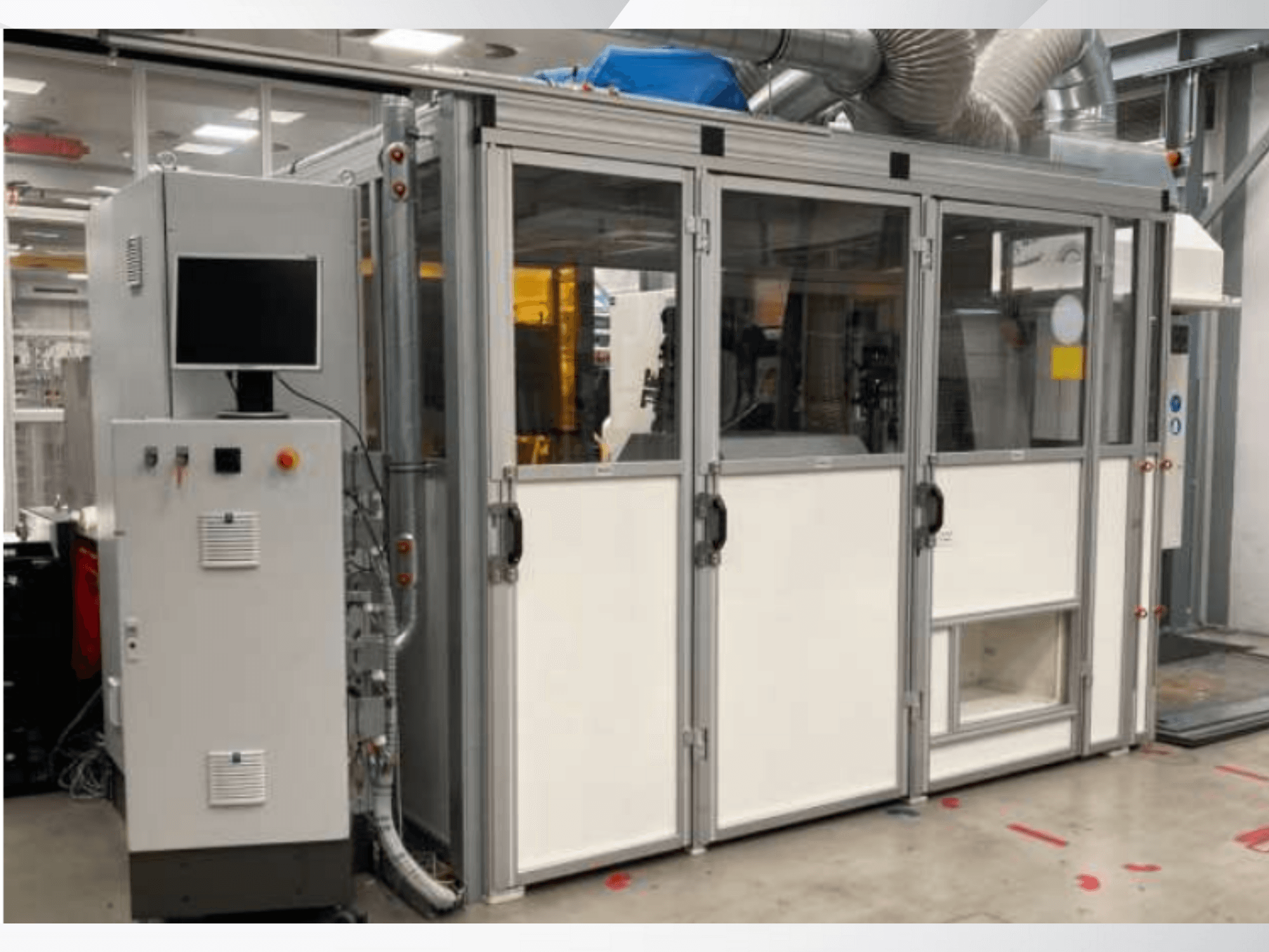 Rūpnieciskā iekārta ar vadības paneli, skats no priekšpuses; stikla durvis, ventilācijas kanāli un redzami vadi.