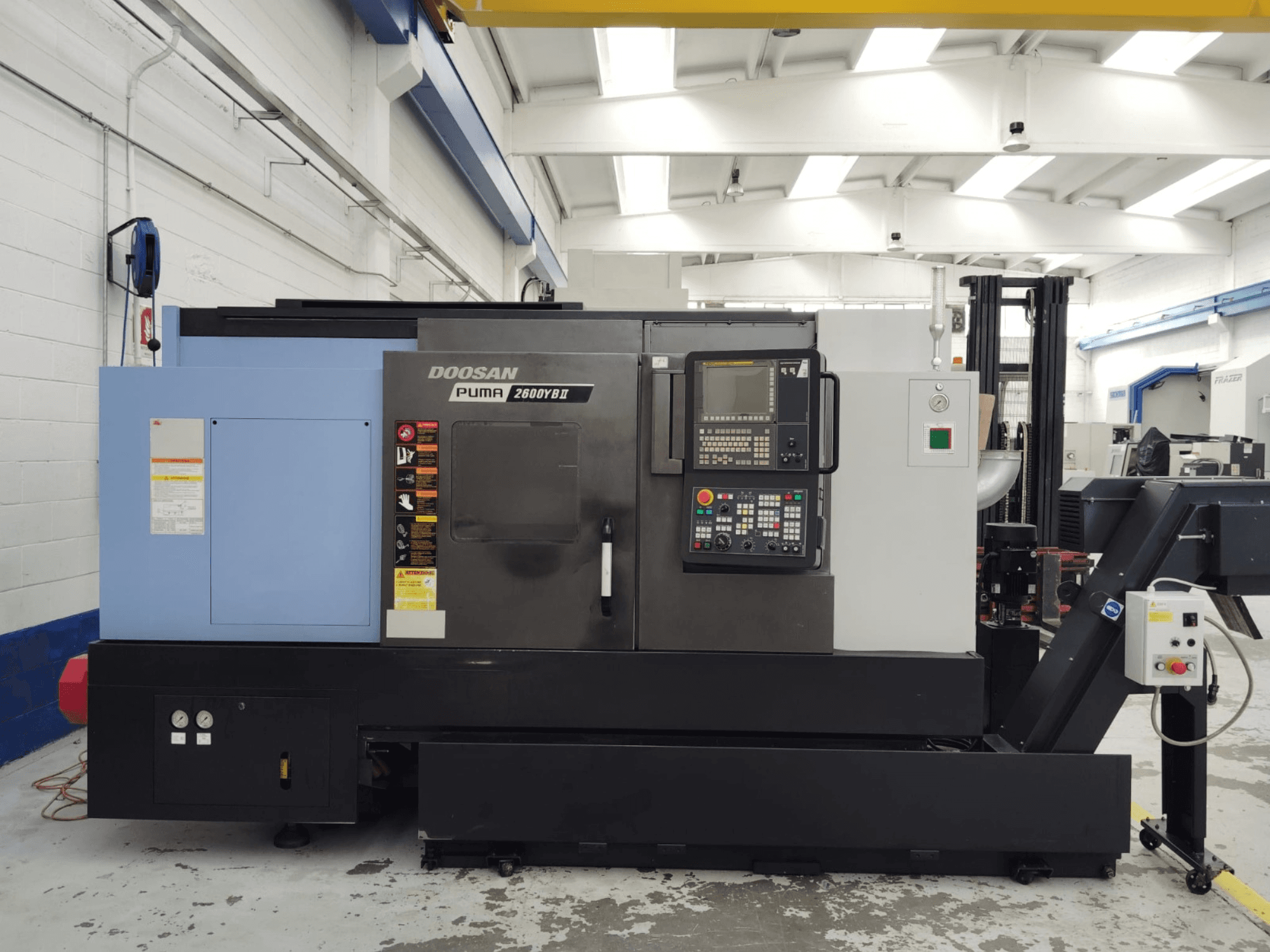DOOSAN Puma 2600YB II horizontālās virpošanas mašīnas priekšējais skats ar redzamu vadības paneli un drošības marķējumu.