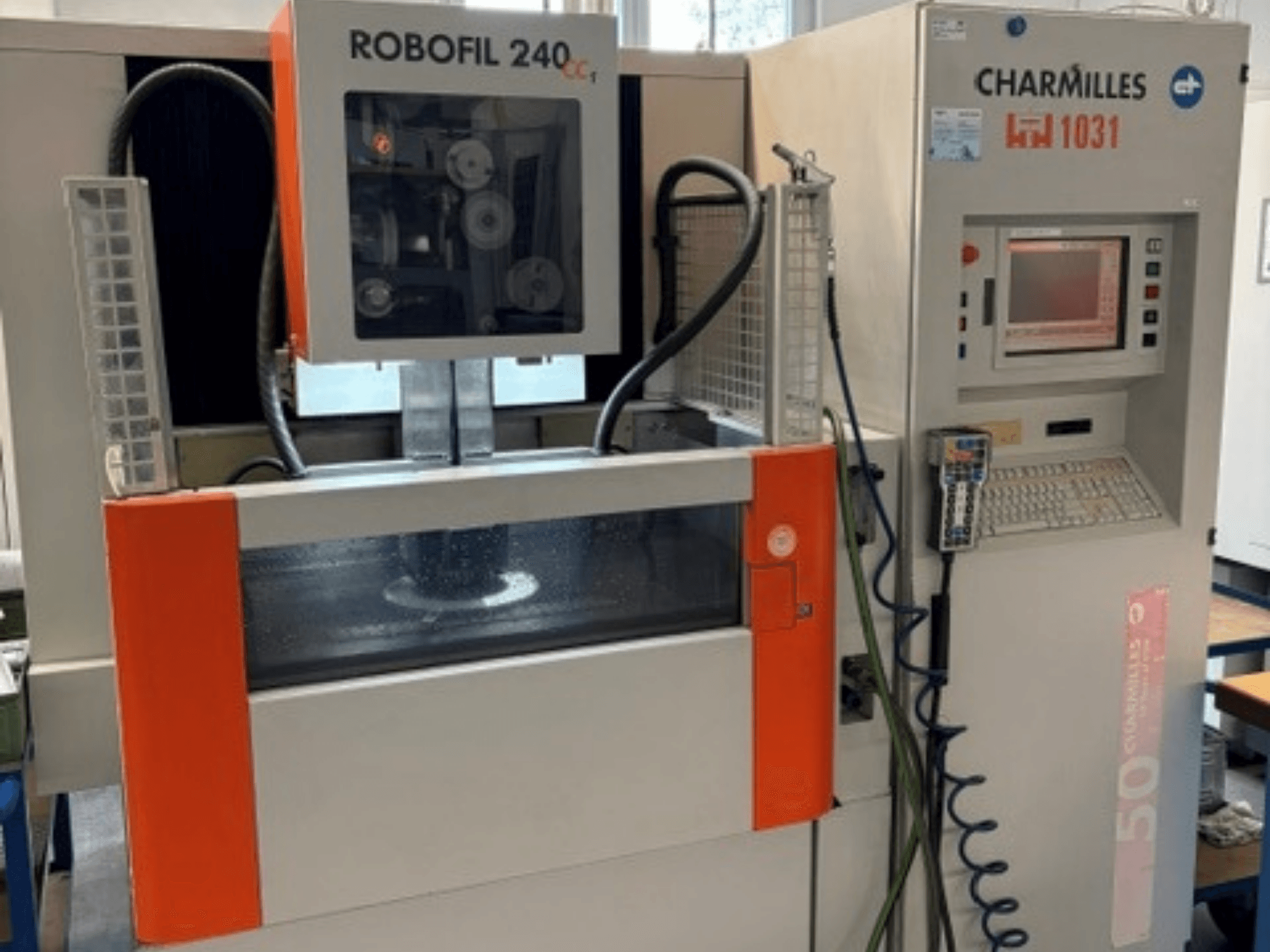 Charmilles Robofil 240 CC stiepļu elektroerozijas mašīna, skats no priekšpuses, kurā redzams vadības panelis un ūdens tvertnes zona.