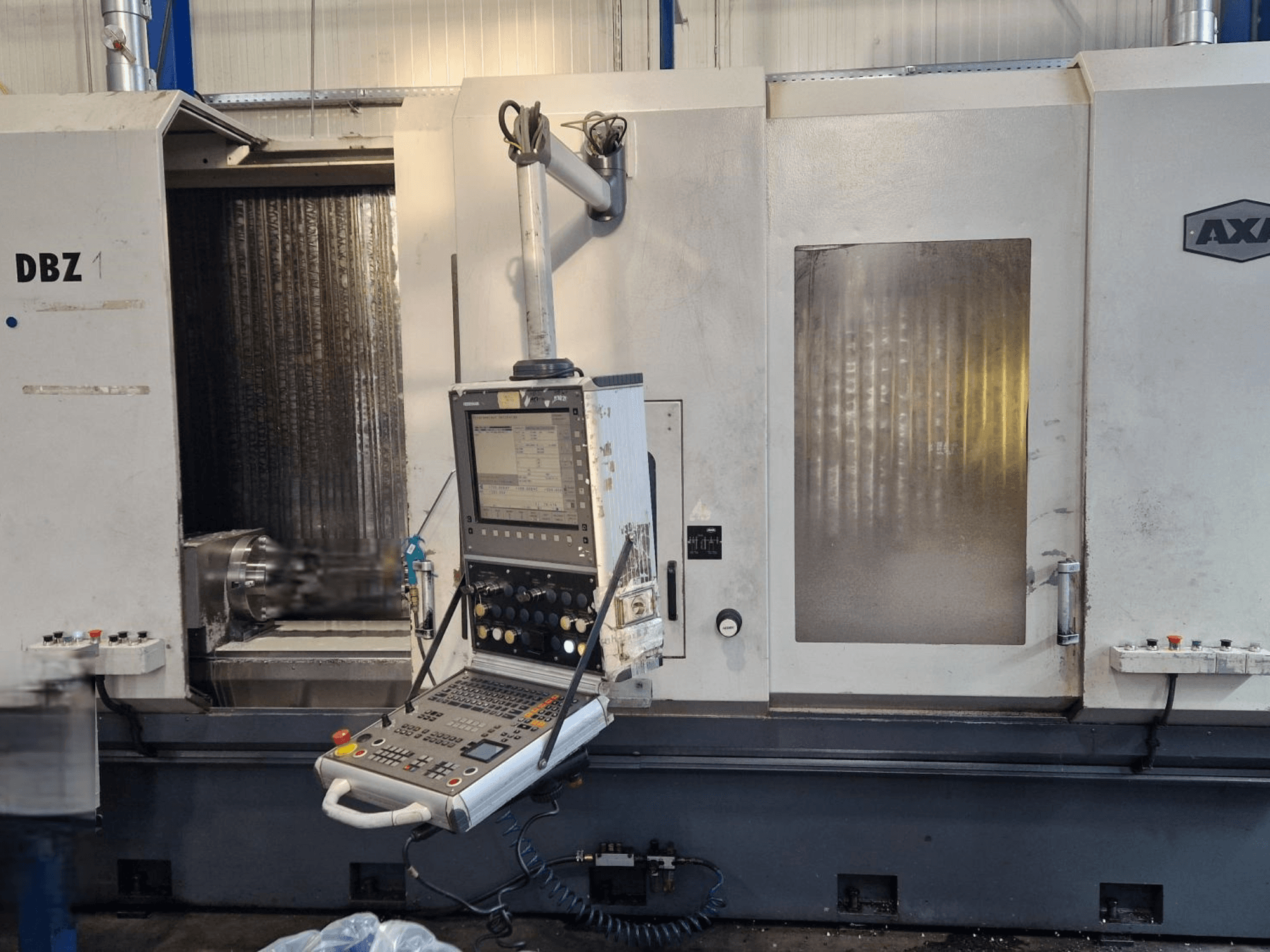 AXA DBZ vertikālais apstrādes centrs no priekšpuses leņķiskā skatā ar vadības paneli un redzamu griezējinstrumentu zonu.