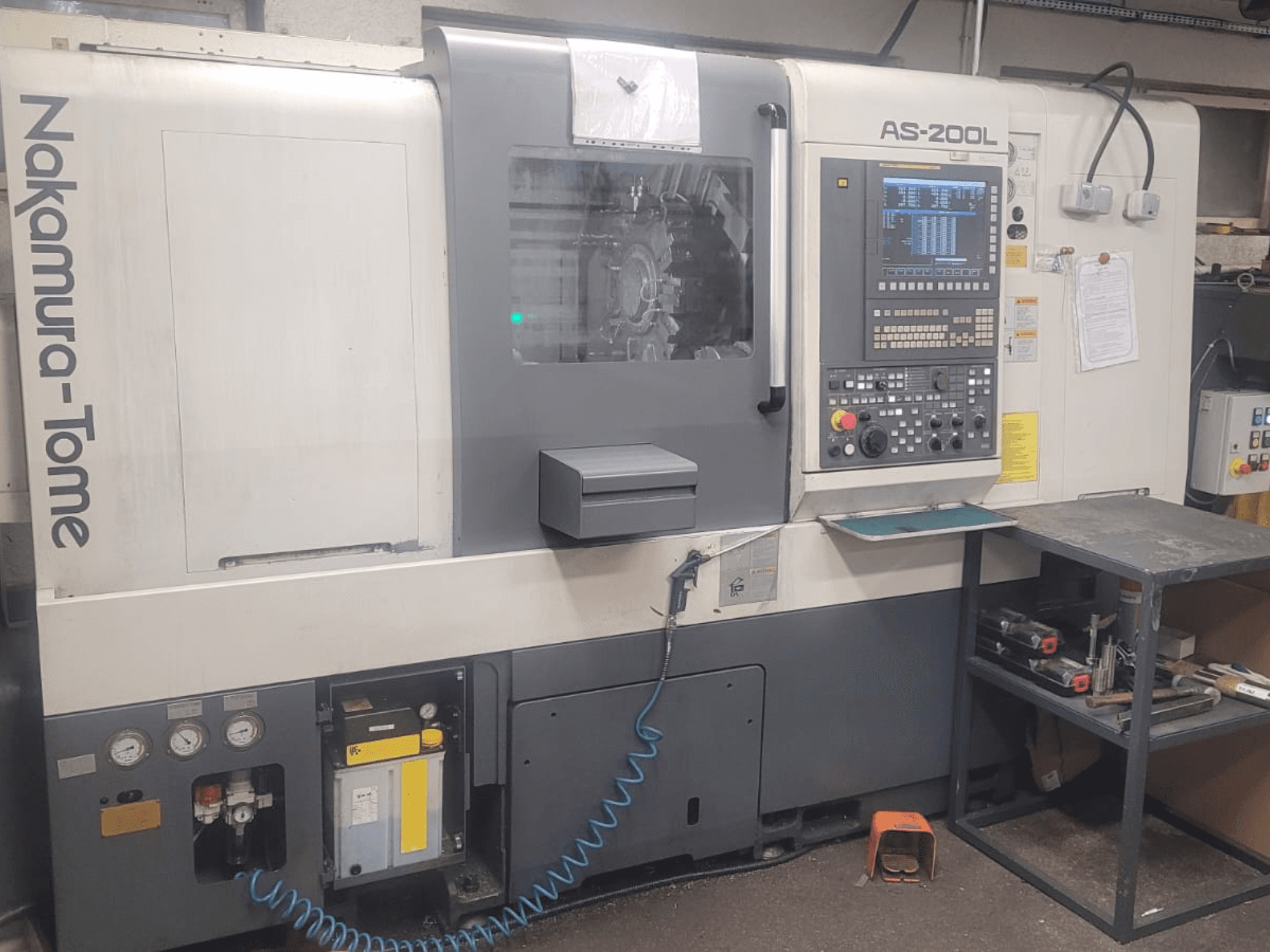 NAKAMURA-TOME AS-200L horizontālās virpošanas darbgalds, priekšējais skats, kurā redzams vadības panelis, vārpsta un darbgala funkcijas.