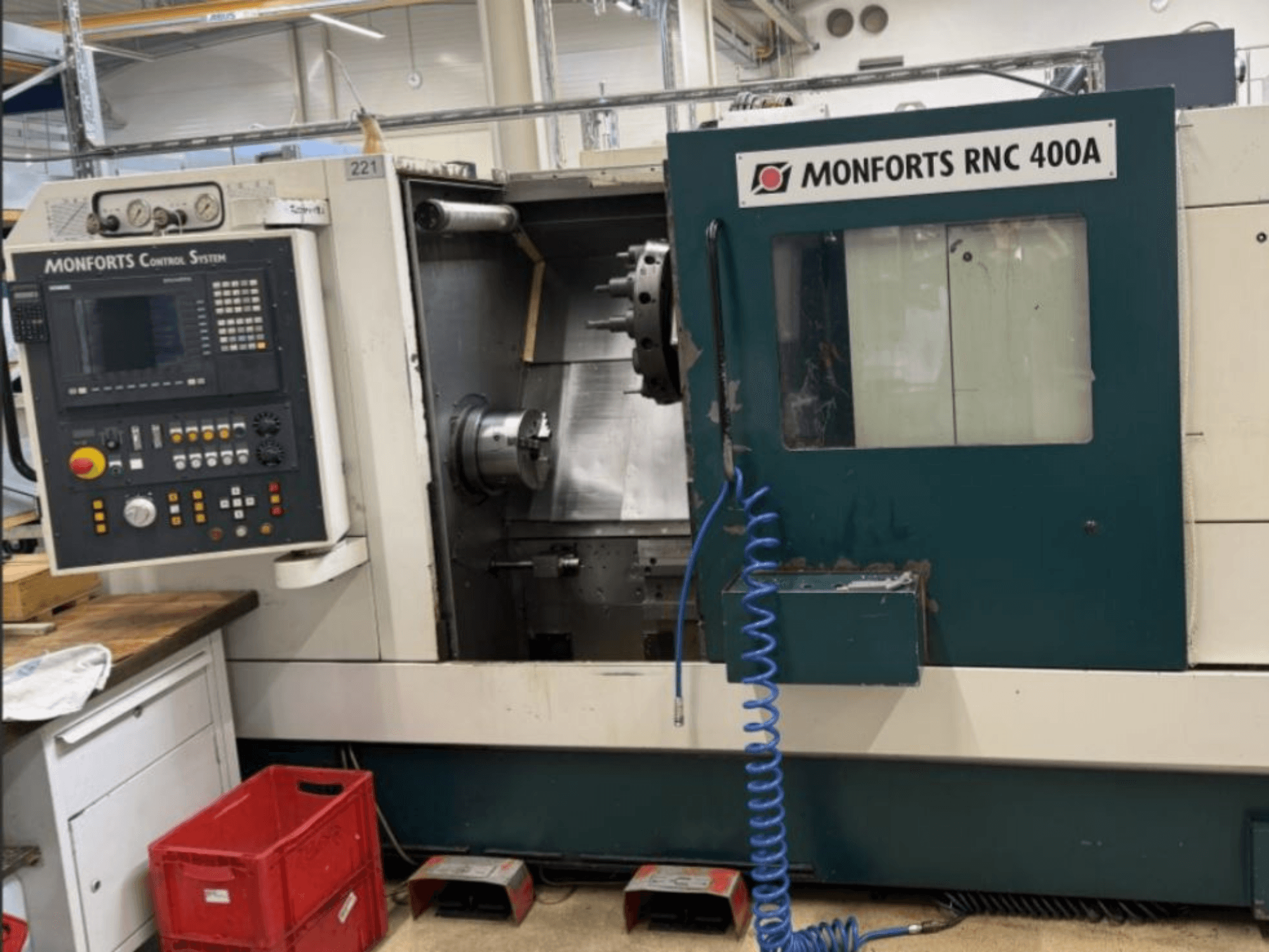 Monforts RNC 400 A horizontālās virpošanas iekārta, skats no priekšpuses, vadības panelis un darba zona ar izceltām funkcijām.