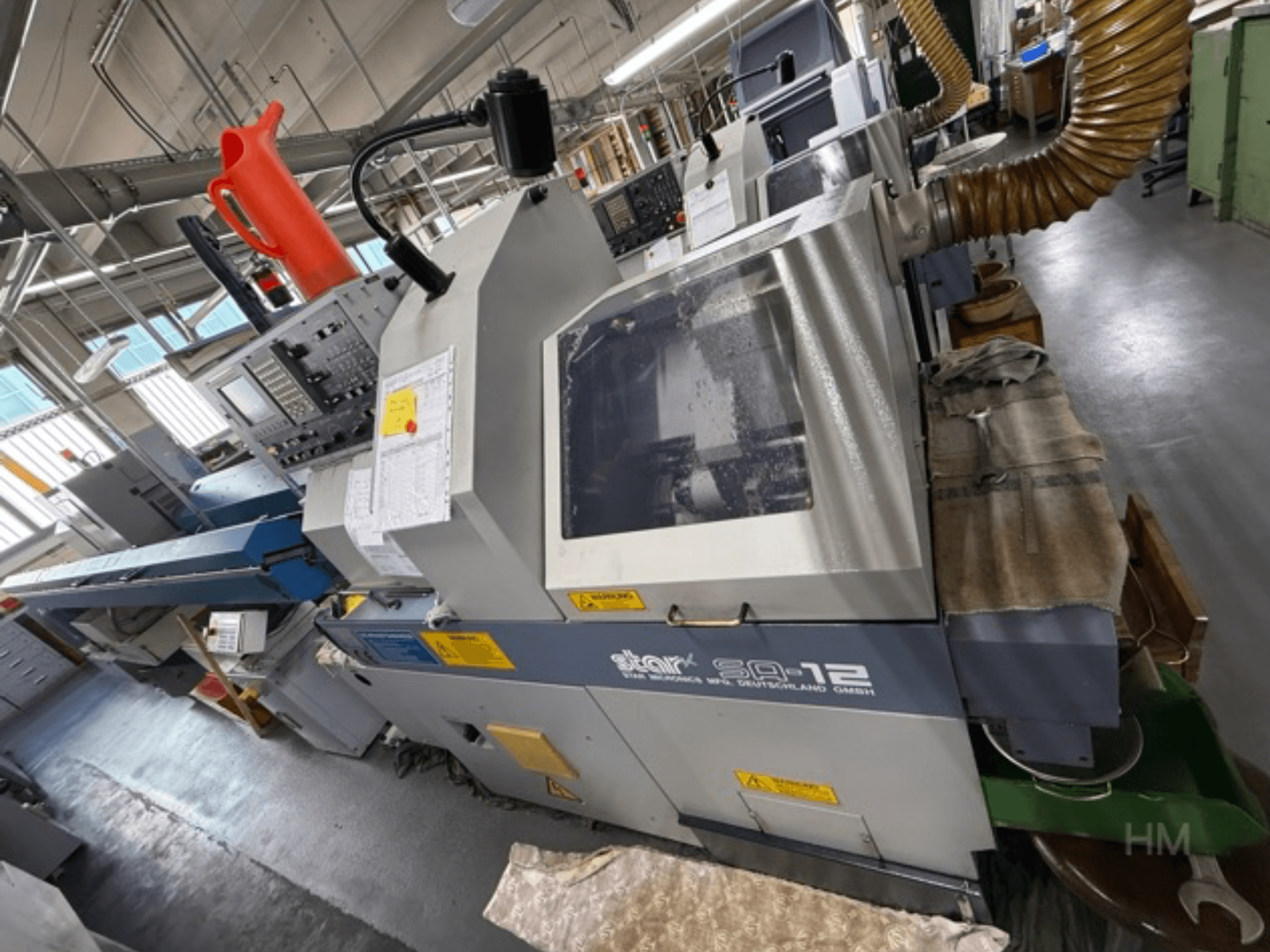 Apstrādes centrs Star SQ-12, skats no sāniem, redzams vadības panelis, dzesēšanas šķidruma tvertne un putekļu nosūces šļūtene.