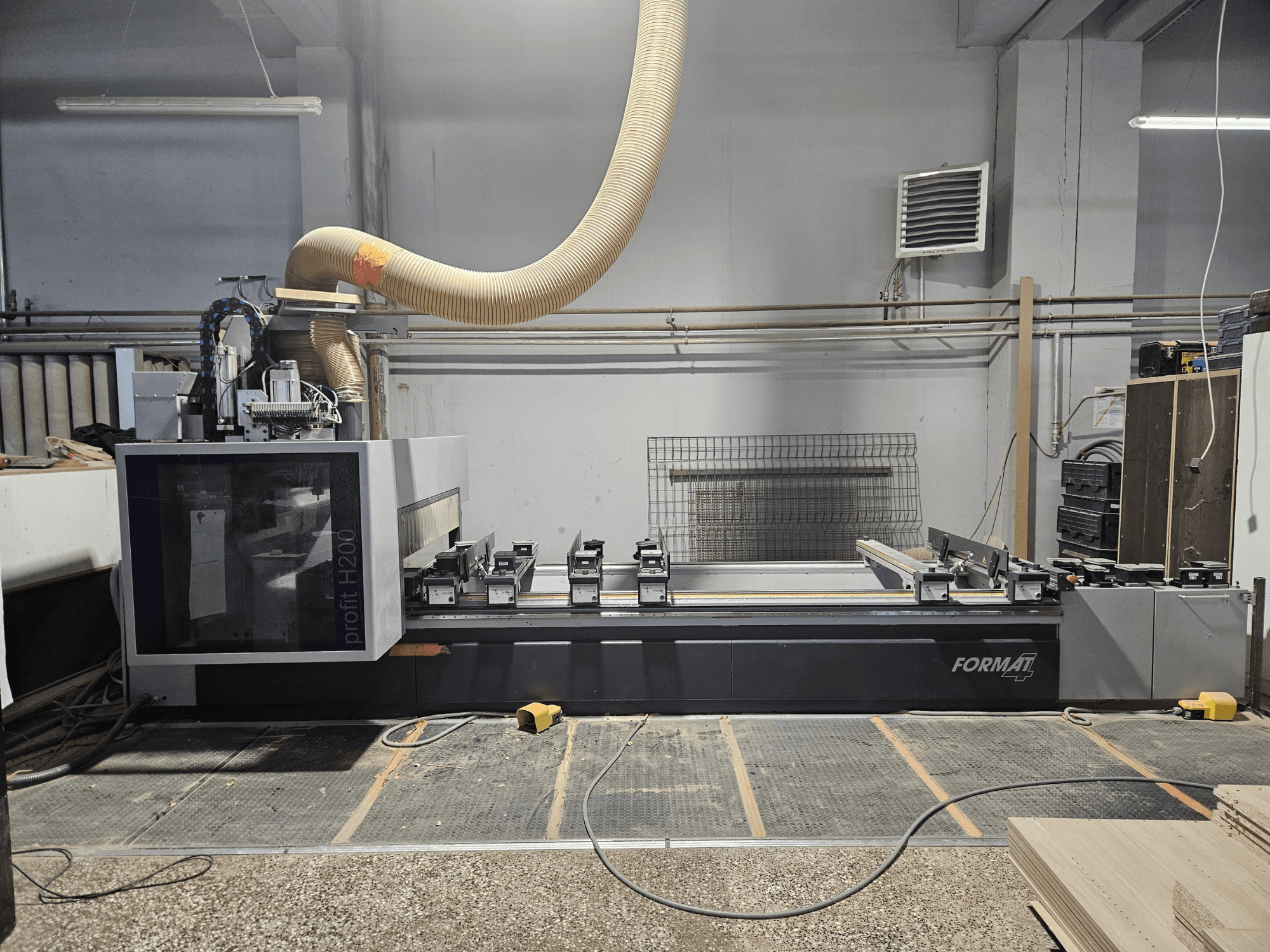 FORMAT profit H200 CNC mašīna darbnīcā, skats no sāniem, redzama darba virsma un putekļu nosūces sistēma.