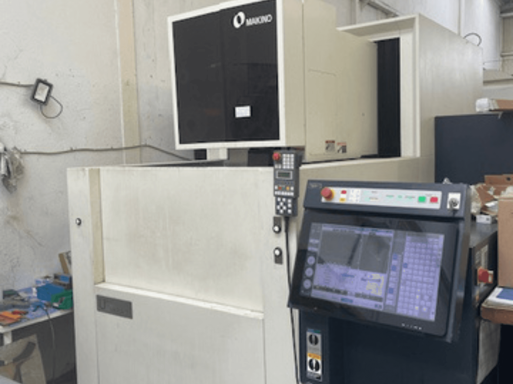 Makino U6 HEAT stiepļu EDM mašīna darbnīcā, priekšējais skats ar vadības paneli un digitālo displeju.