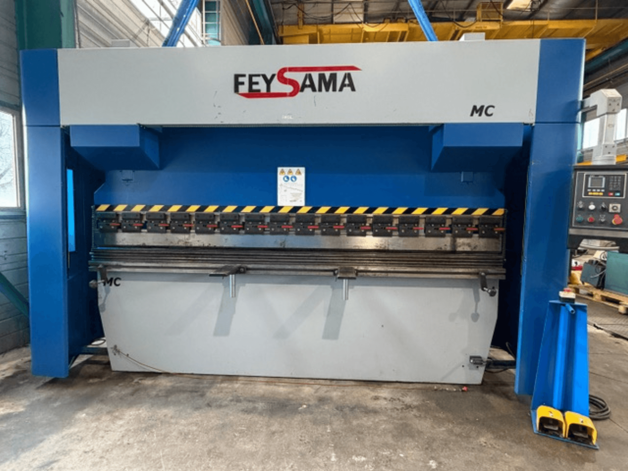 FEYSAMA MCCH 6/3050 preses bremzes priekšējais skats ar dzelteniem drošības marķējumiem, vadības paneli labajā pusē un izturīgu pamatni.