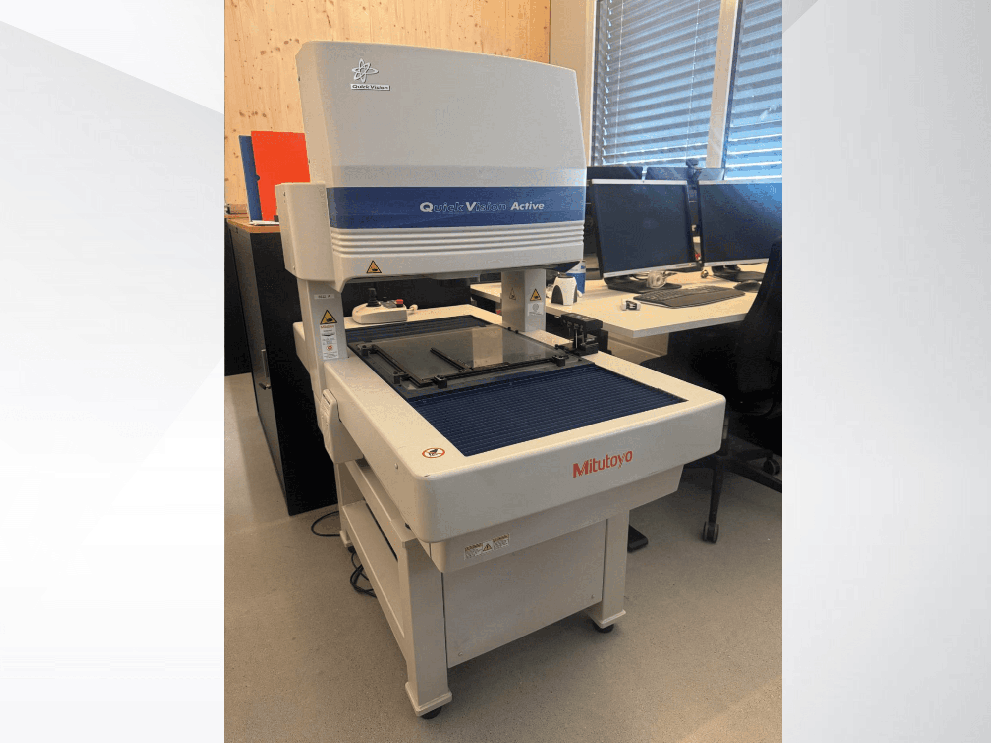 Mitutoyo QV-L404Z1L-D CMM priekšpusē, ar stikla mērīšanas galdu un redzamu vadības paneli ar pogām.