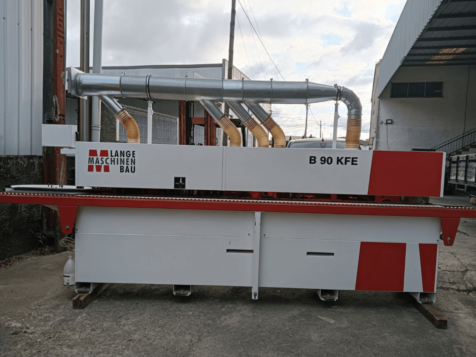 LANGE Maschinenbau B 90 KFE malu līmēšanas mašīna, skats no sāniem, ar divām izplūdes caurulēm un sarkaniem akcentiem, novietota rūpnieciskā darba vidē.