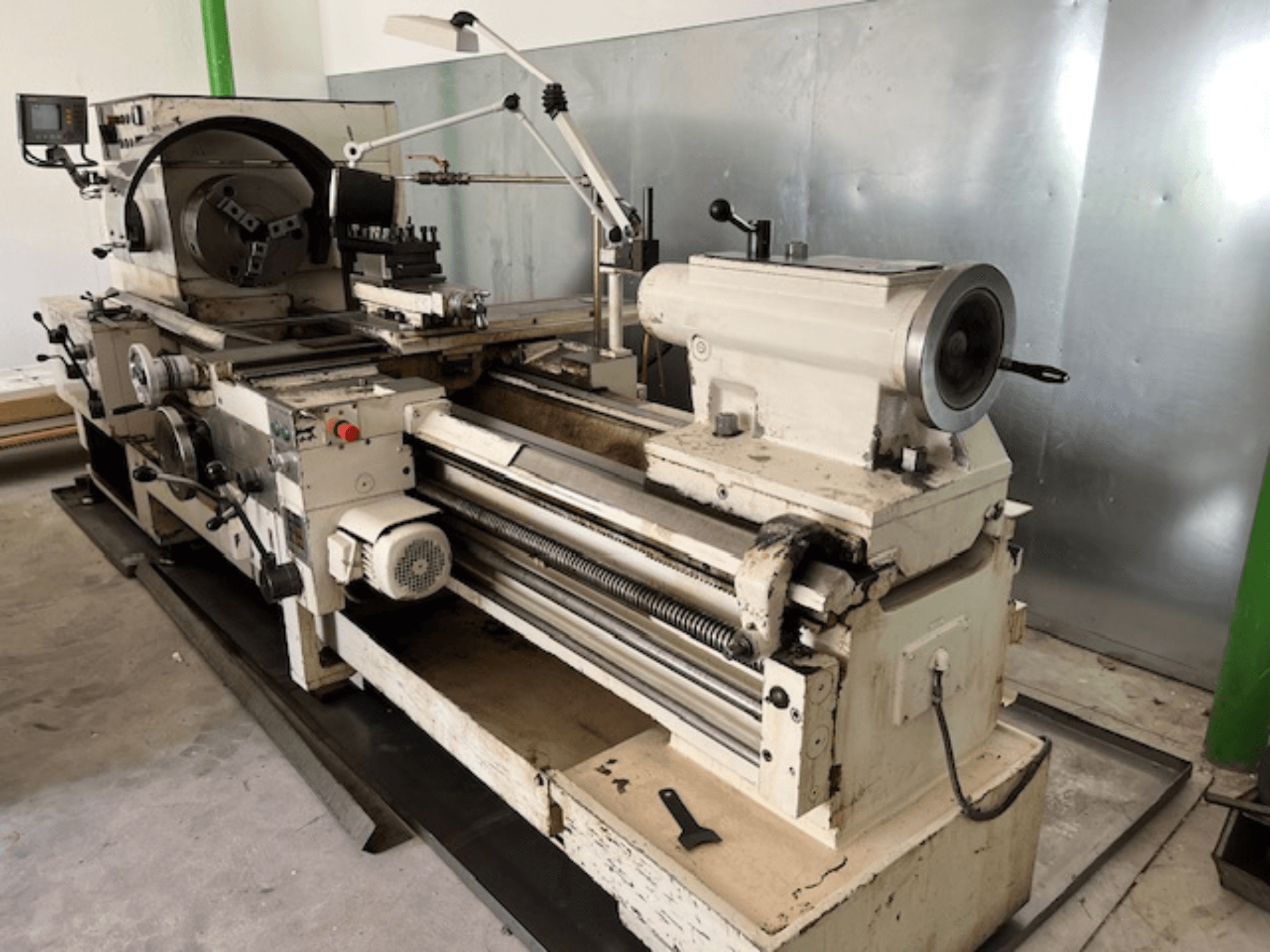 Vintage metāla virpas darbgalds ar vadības paneli un instrumentiem, skats no sāniem, redzami darbības elementi un metāla apdare.