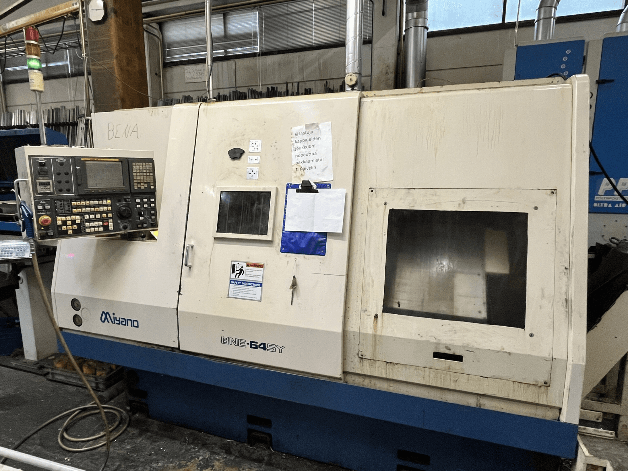 Miyano BNE-64SY CNC virpmašīna, skats no priekšpuses, vadības panelis ar pogām, LCD displejs un tehniskās apkopes uzlīmes uz korpusa.