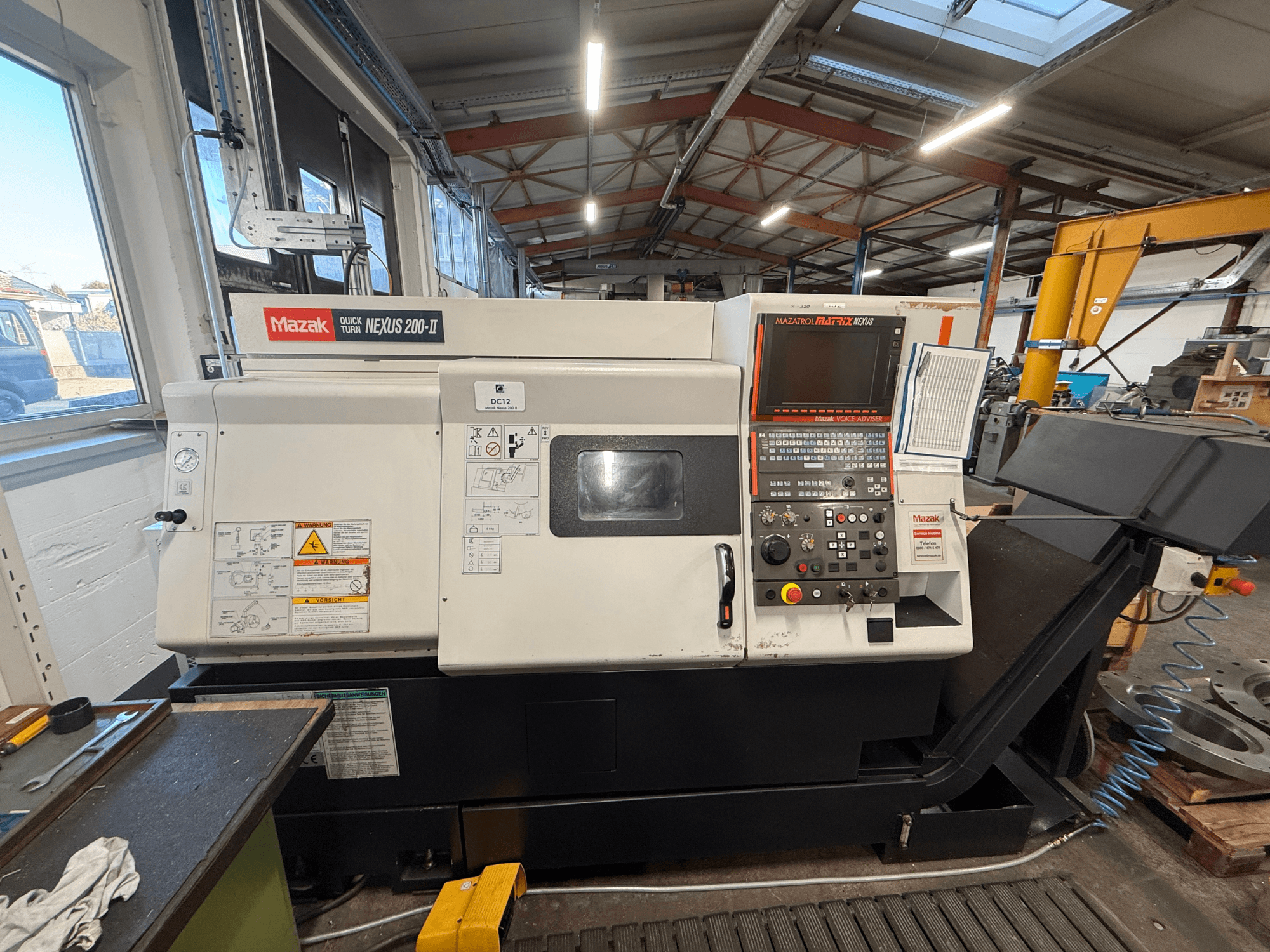 Mazak QUICK TURN NEXUS 200-II horizontālā virpošanas mašīna, skats no priekšpuses, kurā redzams vadības panelis un darbības funkcijas.