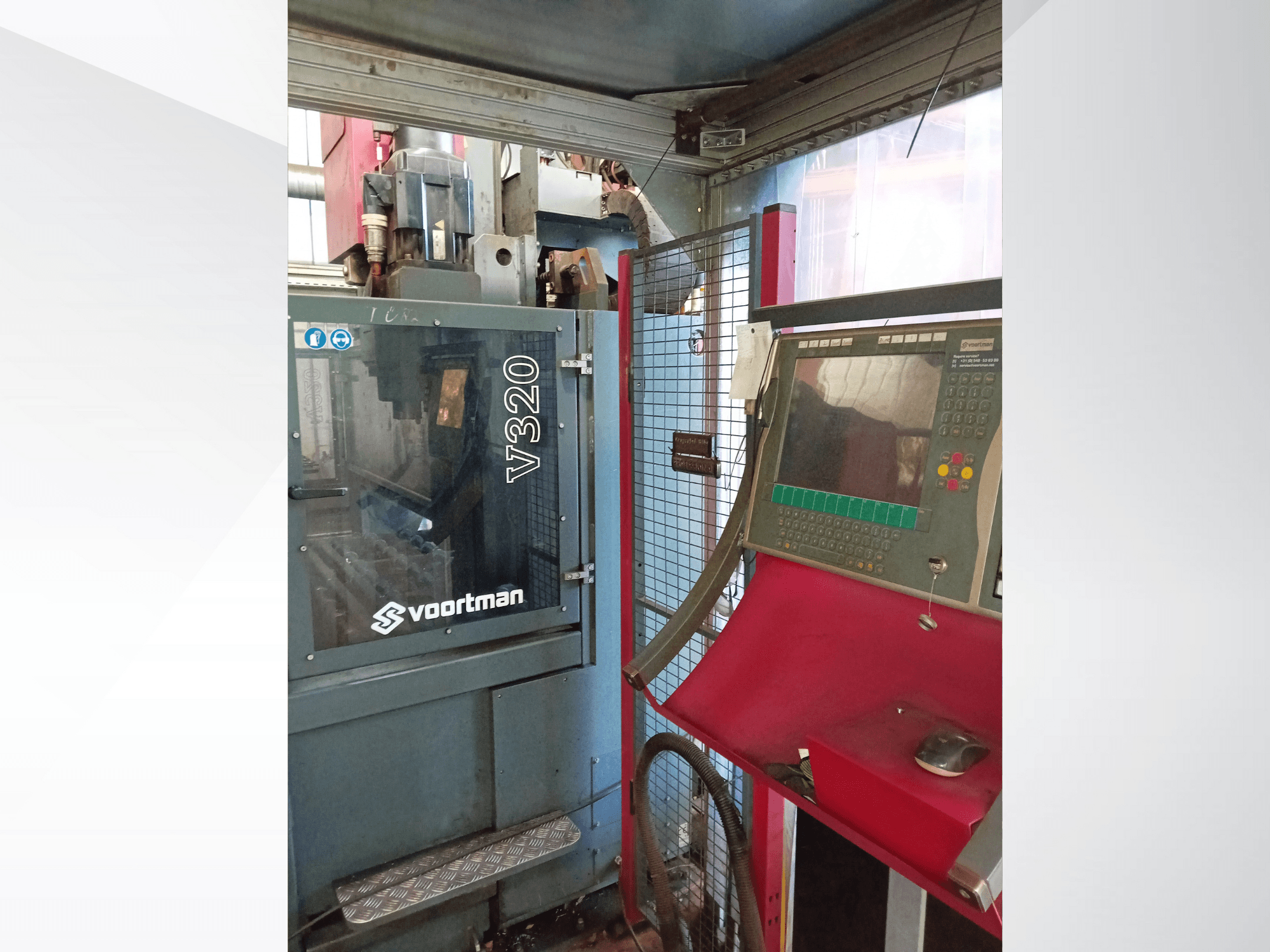 Voortman V320 CNC mašīnas priekšējais skats ar vadības paneli ar pogām, displeja ekrānu un drošības tīkla apvalku.