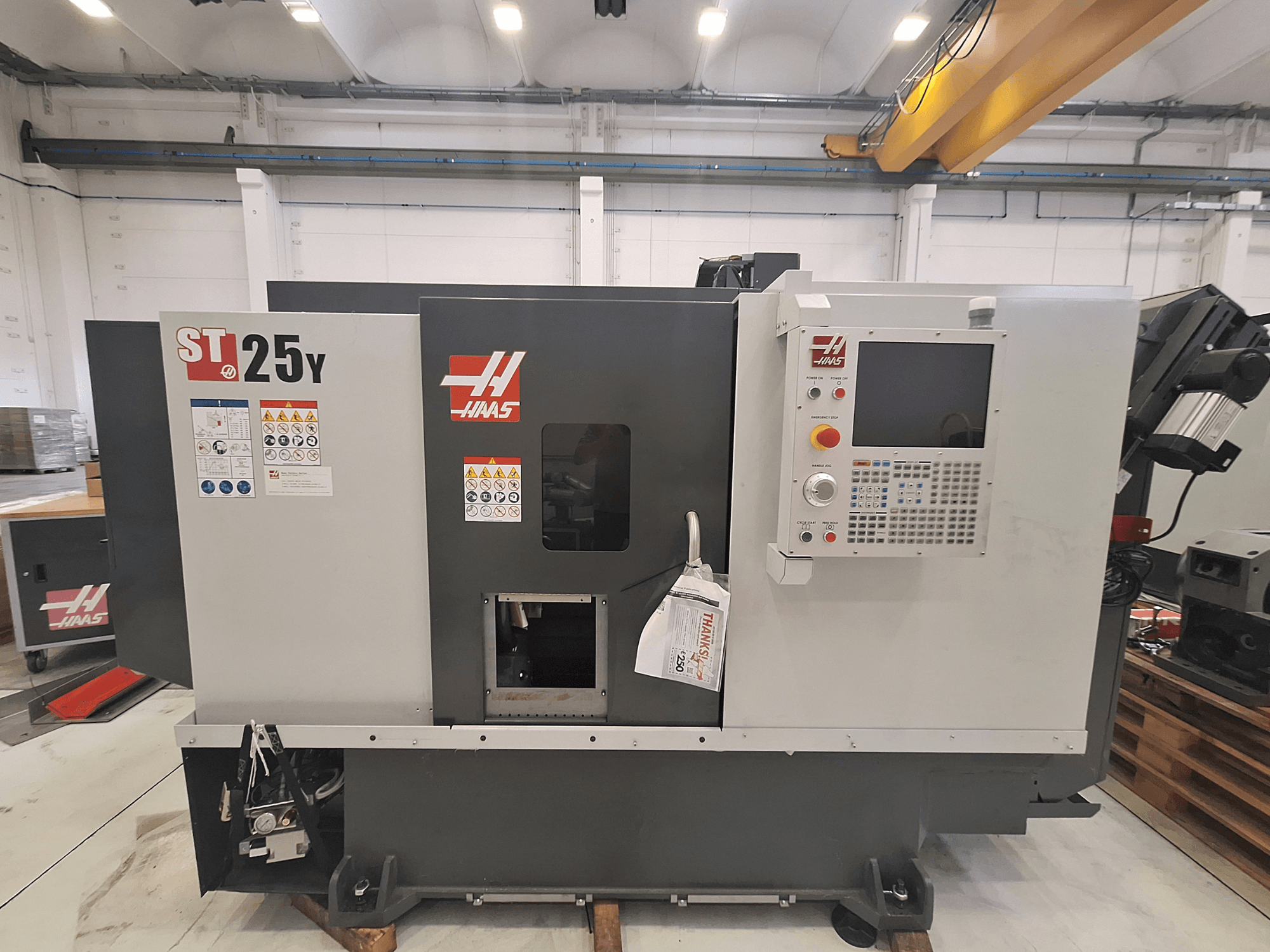 Haas ST-25Y horizontālā virpošanas mašīna, skats no priekšpuses, ar vadības paneli un drošības uzlīmēm. Ideāli piemērota precīzai apstrādei.