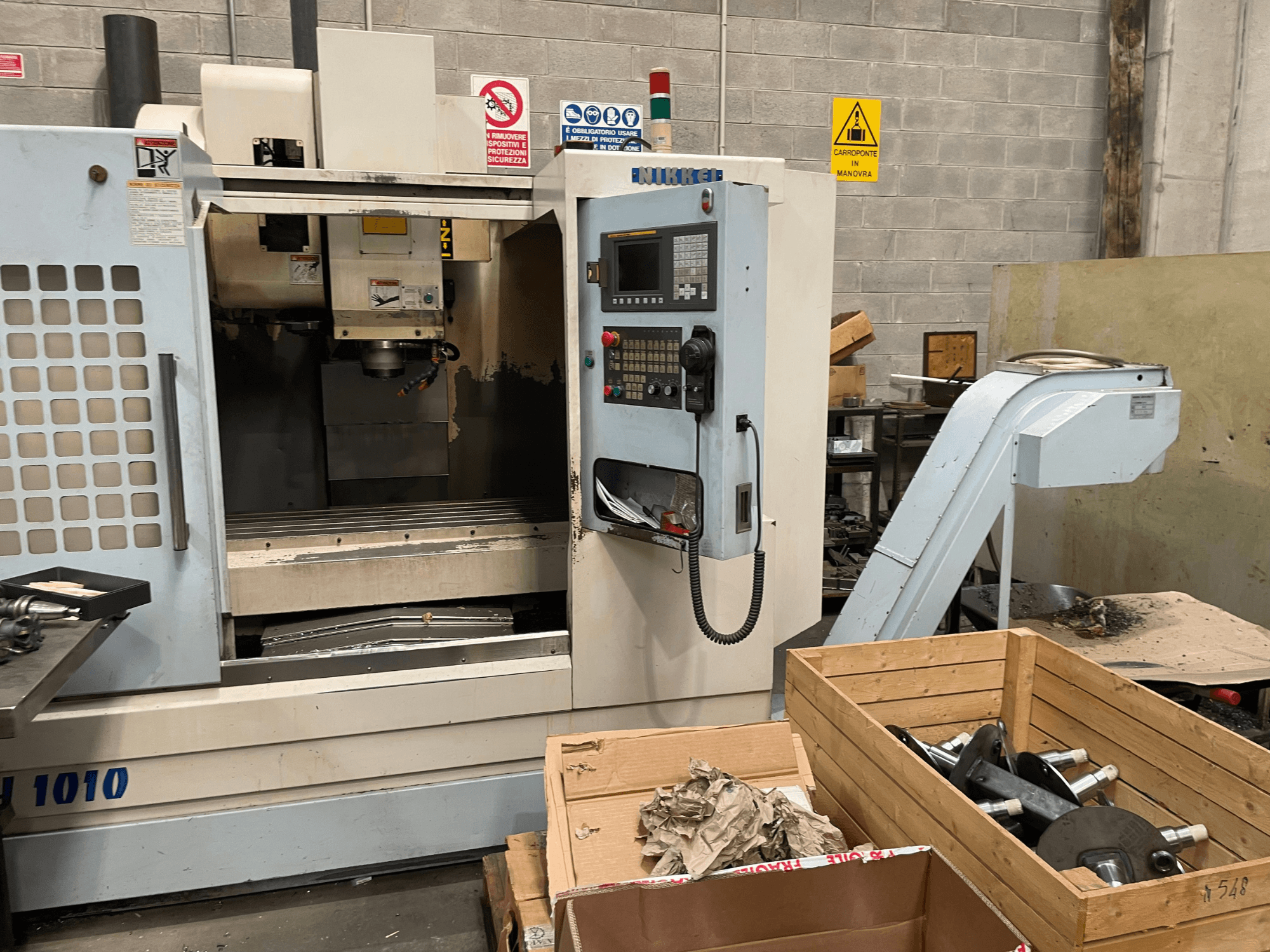 Cita ražotāja vertikālais apstrādes centrs, modelis VH-1010, skatīts no priekšpuses ar redzamām vadības ierīcēm un blakus esošajām kastēm.