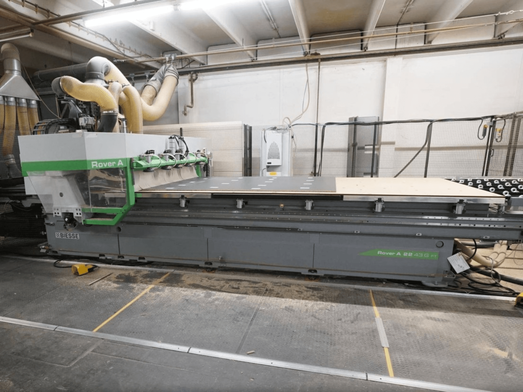 CNC koka apstrādes centrs BIESSE Rover A FT 2243, skats no priekšpuses, ir aprīkots ar lielu darba galdu un instrumentu piestiprināšanas sistēmu.