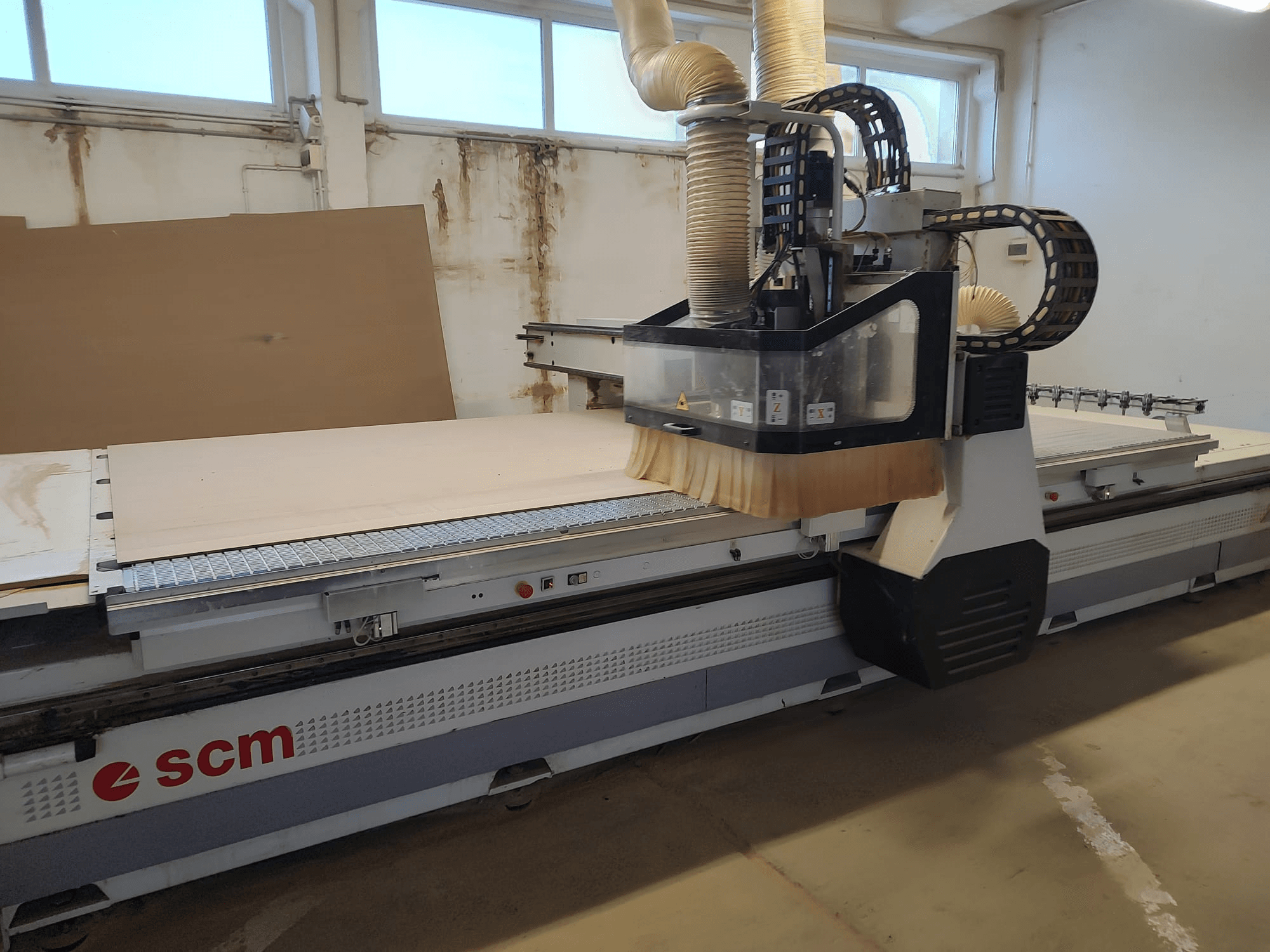 SCM ACCORD 20 CNC frēze priekšpusē, kas demonstrē griešanas galvu un lielo darba galdu, kas ir ideāli piemērots kokapstrādes darbiem.