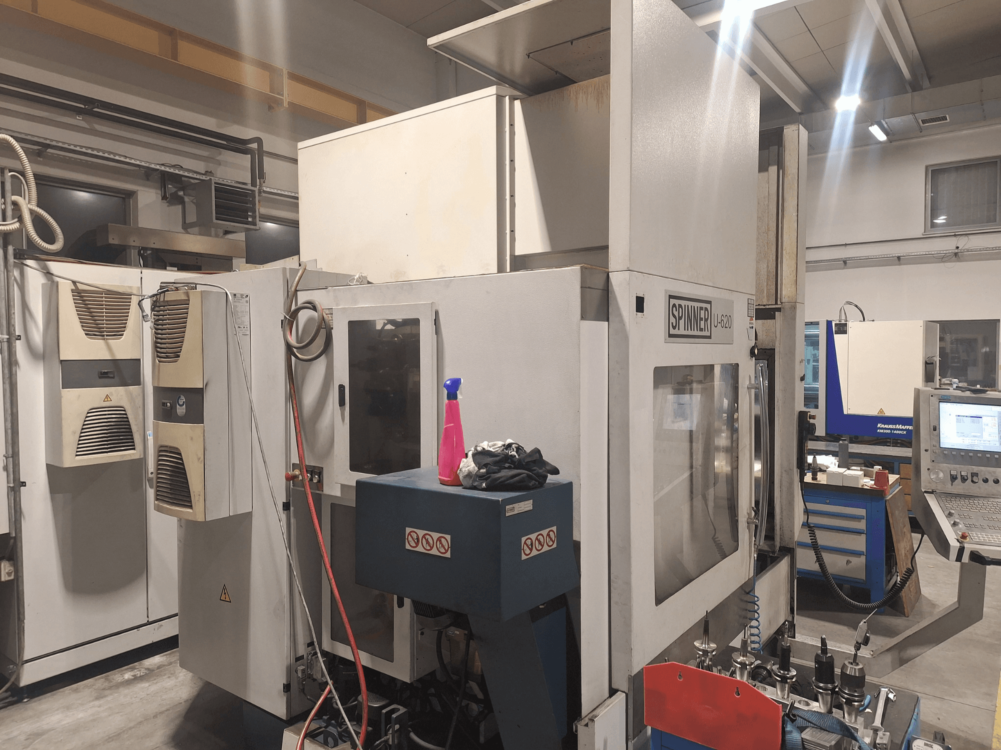 CNC darbnīca, Spinner U-620 CNC darbagalds no priekšpuses, ar vadības paneli un dažādiem instrumentiem uz darbgalda blakus.