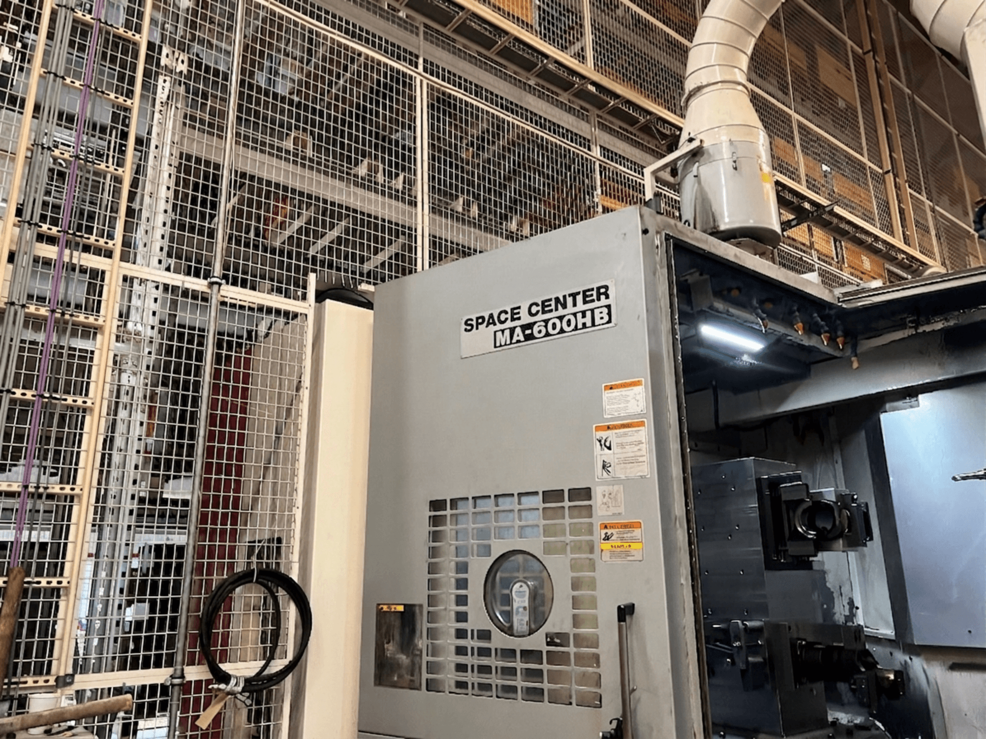 Okuma MA-600HB horizontālais apstrādes centrs, skats no priekšpuses, redzams operatīvais panelis un dzesēšanas šķidruma sprauslas.