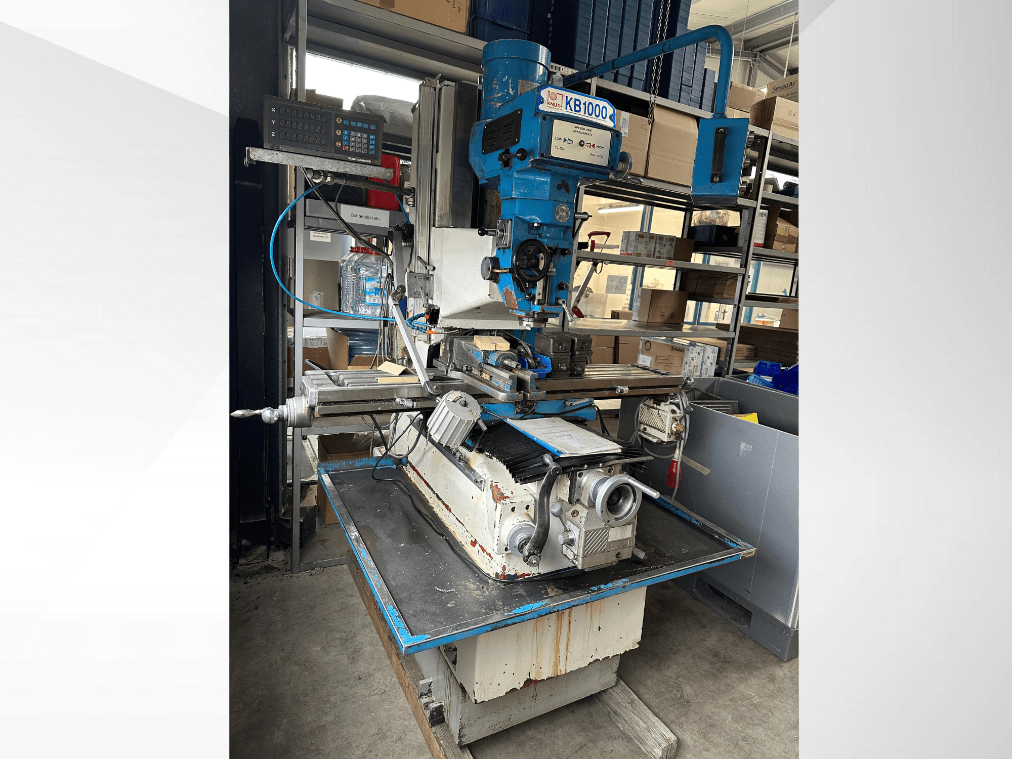 Vertikālās frēzēšanas iekārta KB1000 ar digitālo displeju, sānu skats, kurā redzams galds, vārpsta un instrumentu turētājs.