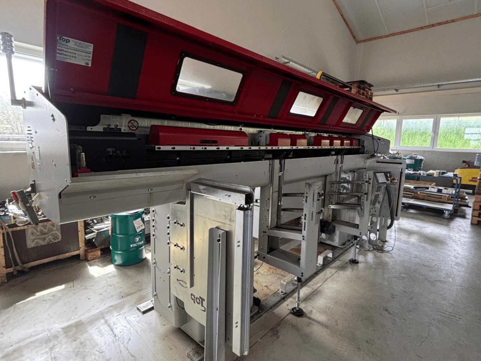 TOP Automazioni Top Loader ETL 10-75, redzams no sāniem, ar sarkanu augšējo daļu un sarežģītām mehāniskām detaļām.