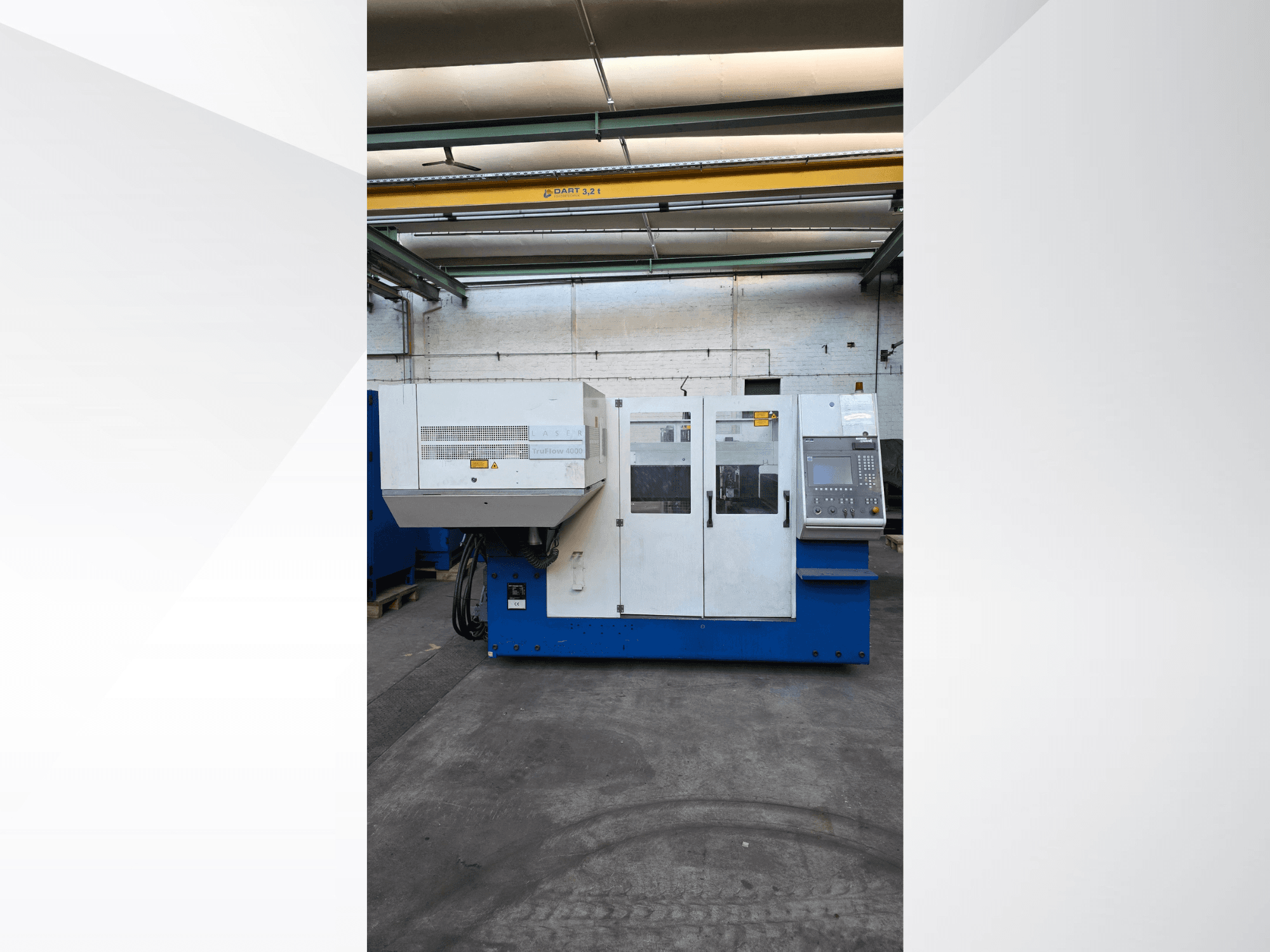 TRUMPF TruLaser 3030 CO2 lāzera griešanas iekārta, skats no priekšpuses, ar vadības paneli un drošības brīdinājumiem ārpusē.