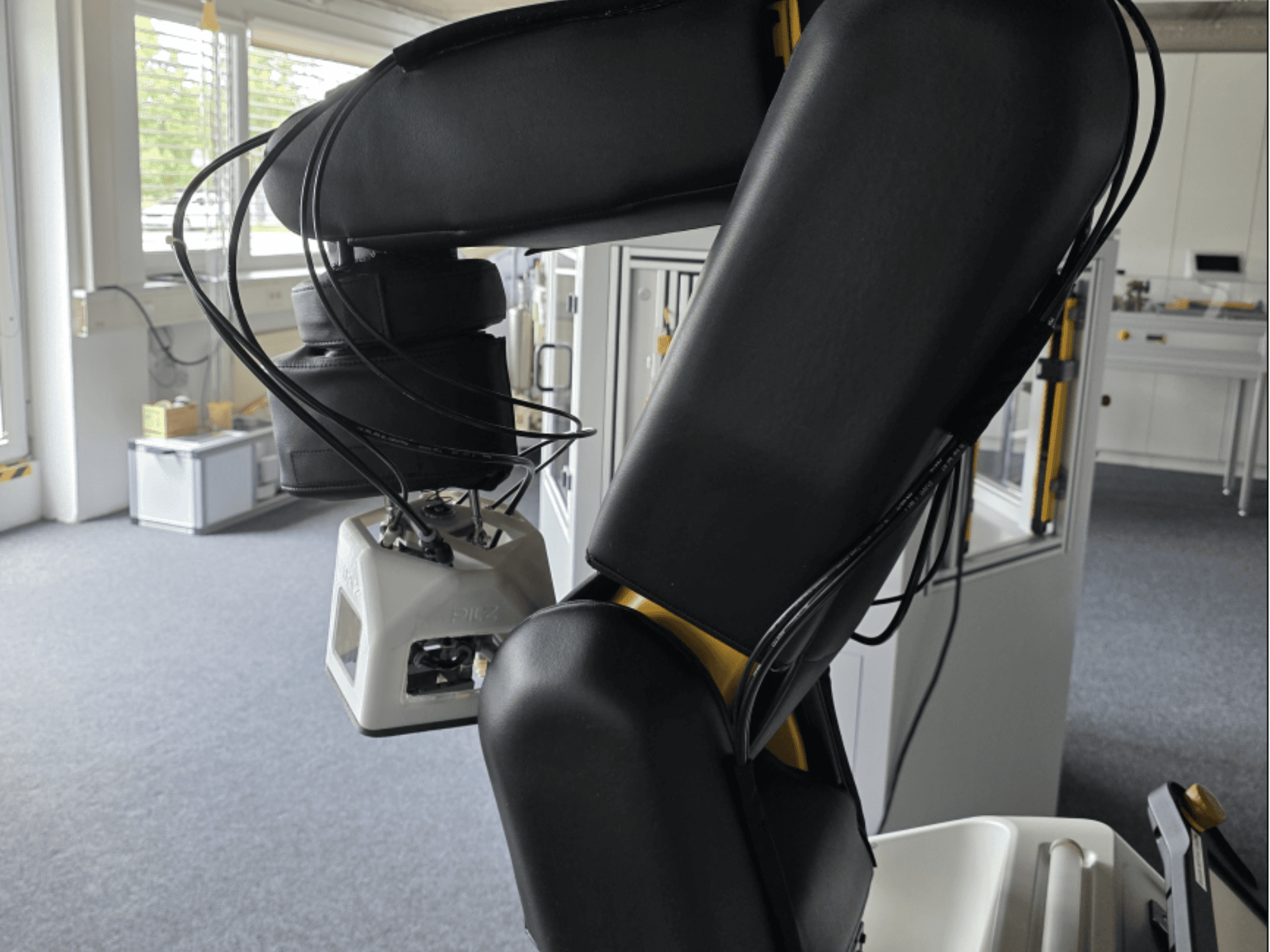 FANUC LR Mate 200iD/7L sadarbības robota sānskats, kurā redzama roka un sensori, kā arī kabeļi darbnīcas vidē.