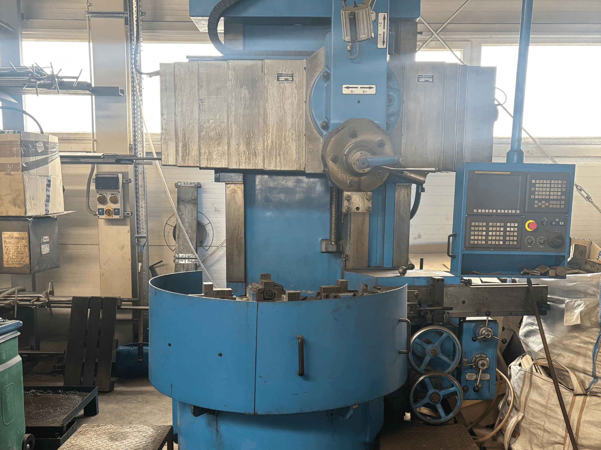 Nezināma zīmola rūpnieciskās frēzmašīnas priekšējais skats ar zilu ārējo apdari un digitālo vadības paneli.