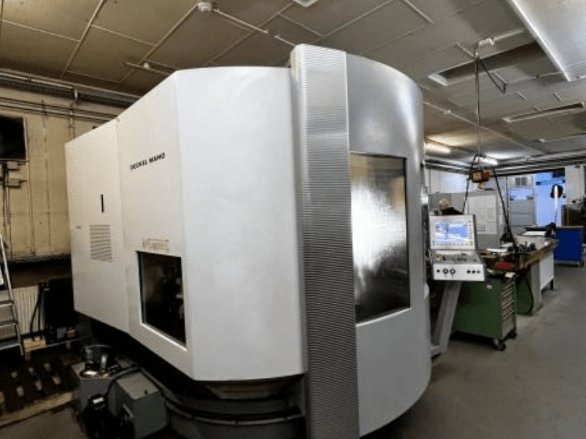 SODICK MAKO CNC darbnīcā, skats no sāniem, fonā redzams vadības panelis un darba zona.