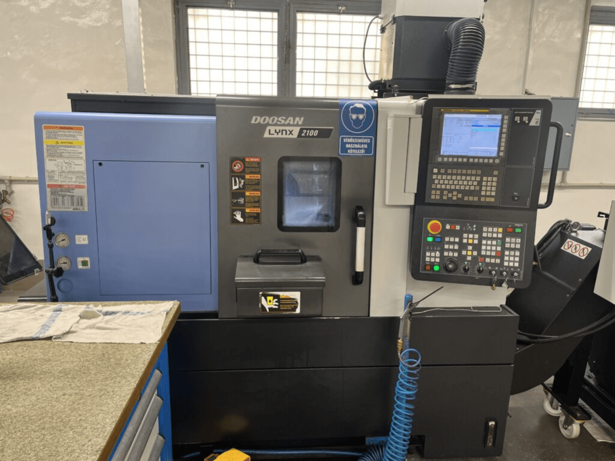 DOOSAN Lynx 2100A horizontālās virpošanas iekārta, priekšējais skats, kurā redzams vadības panelis, operatora saskarne un iekārtas funkcijas.