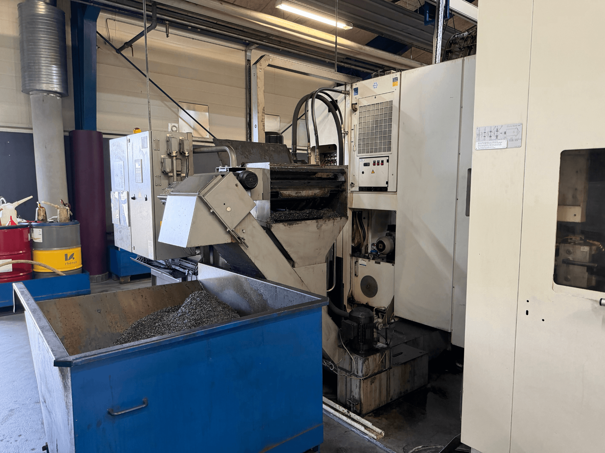 HELLER MCH 250 horizontālā apstrādes centra priekšējais skats ar redzamu metāla dzesēšanas šķidruma pārstrādes tvertni un vadības paneli.