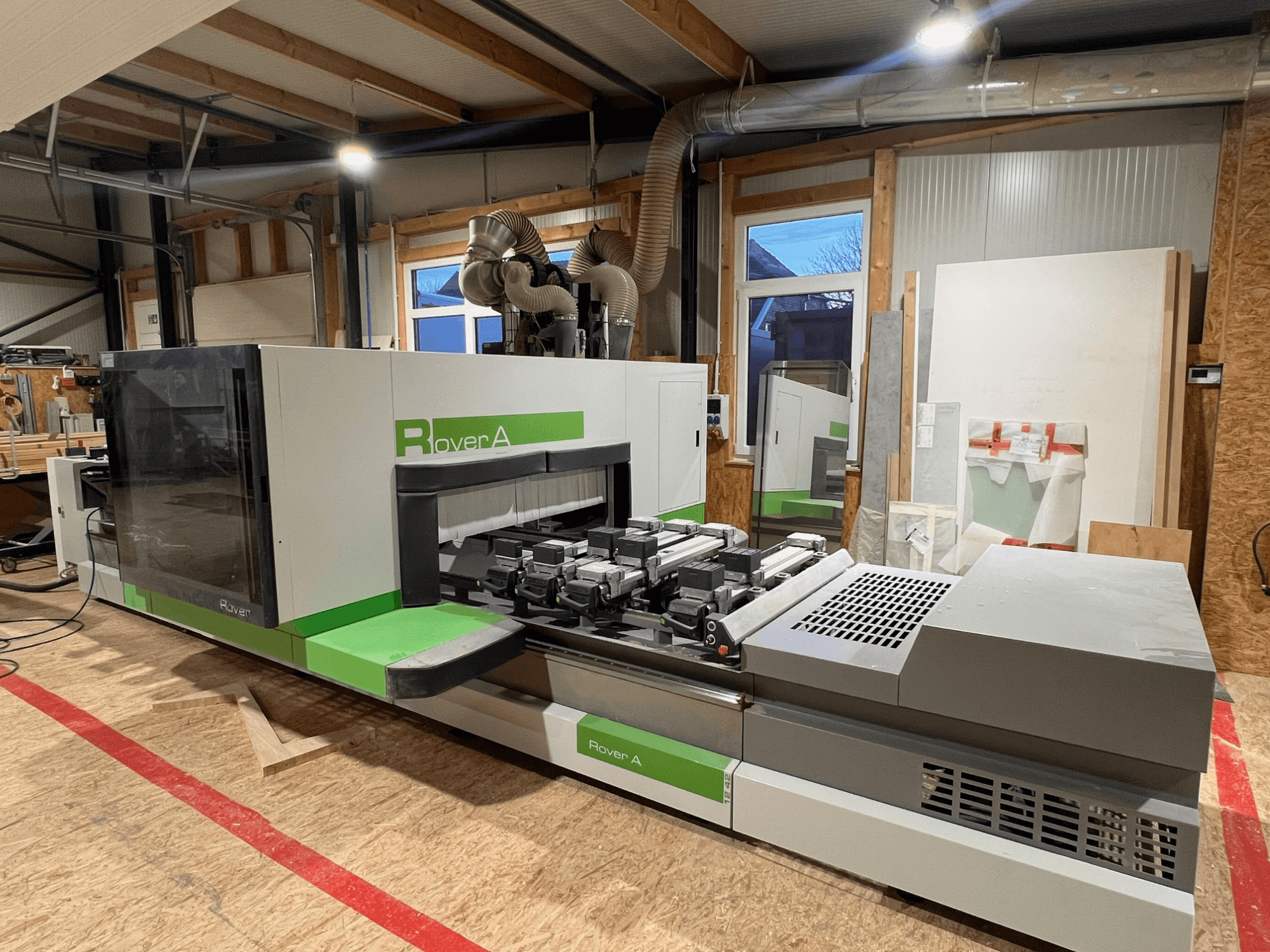 BIESSE Rover A 1242 CNC kokapstrādes centrs, priekšējais skats, kurā redzams vadības panelis un griešanas zona darbnīcā.