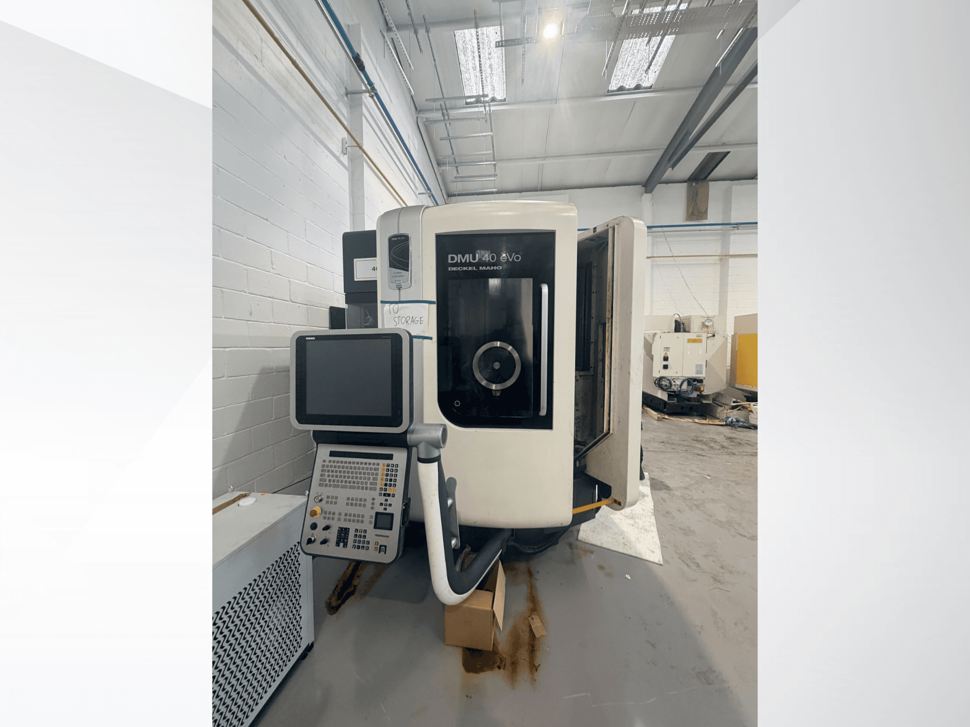 DMG DMU 40 evo vertikālā apstrādes centra skats no priekšpuses, kurā redzams vadības panelis un vārpstas zona, bet fonā — darba laukums.