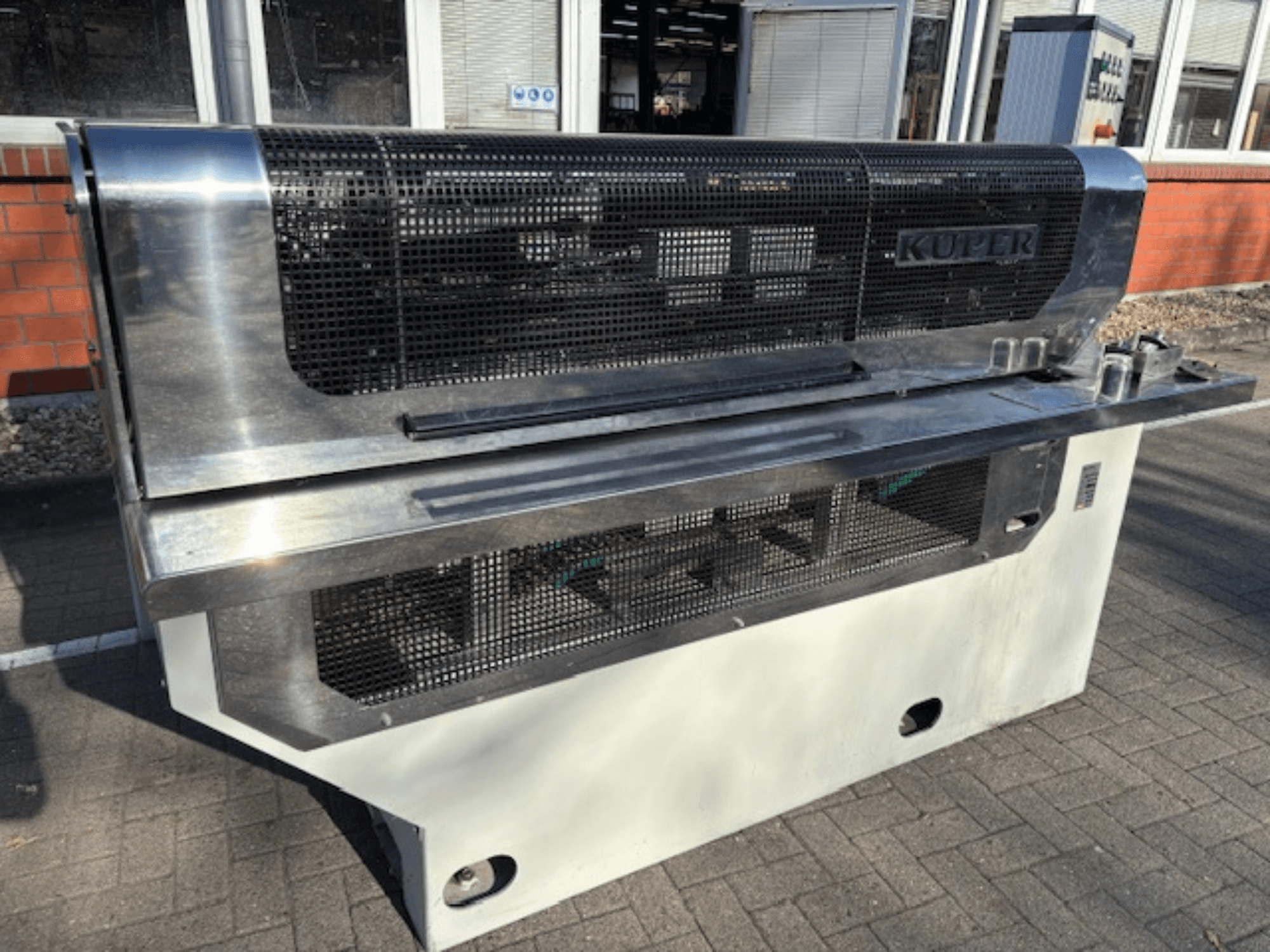 KUPER FLI finiera giljotīna, skats no priekšpuses, ar nerūsējošā tērauda korpusu un aizsargrežģi drošai darbībai.