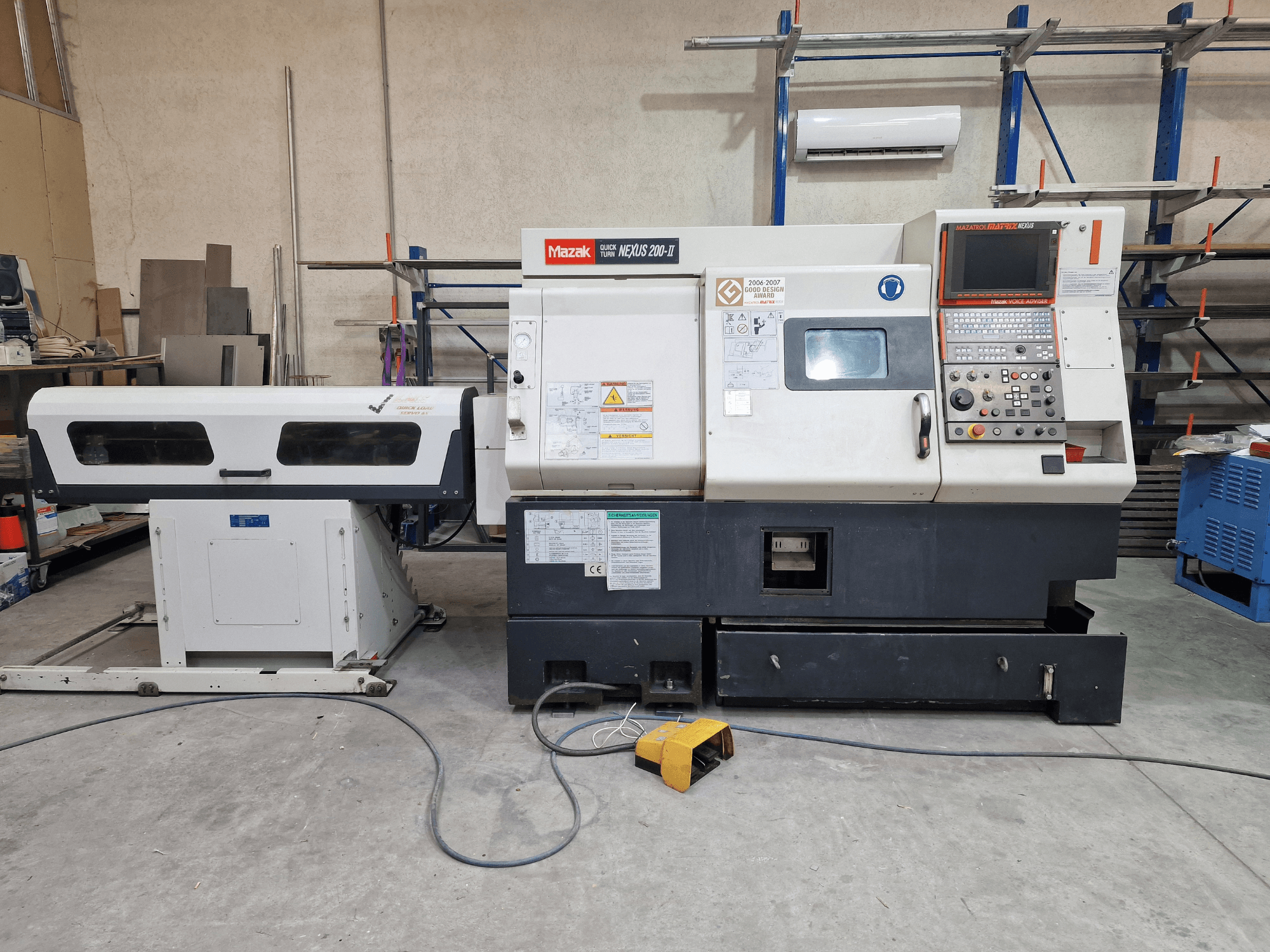 Mazak QuickTurn Nexus 200 horizontālā virpošanas mašīna, skats no sāniem, kurā redzams vadības panelis, vārpsta un skaidu paplāte.