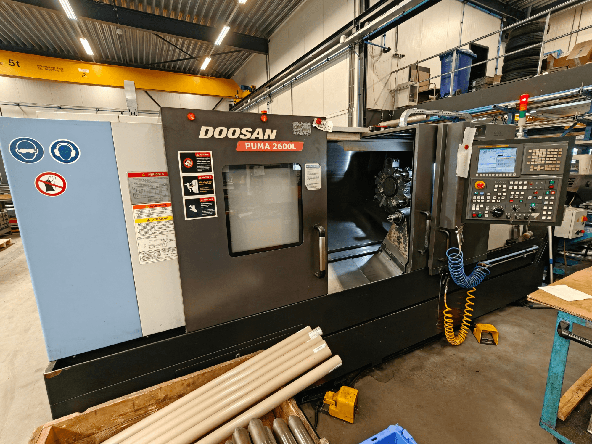 DOOSAN Puma 2600L horizontālās virpošanas iekārta darbnīcā, sānu skats, kurā redzams vadības panelis un vārpstas zona.