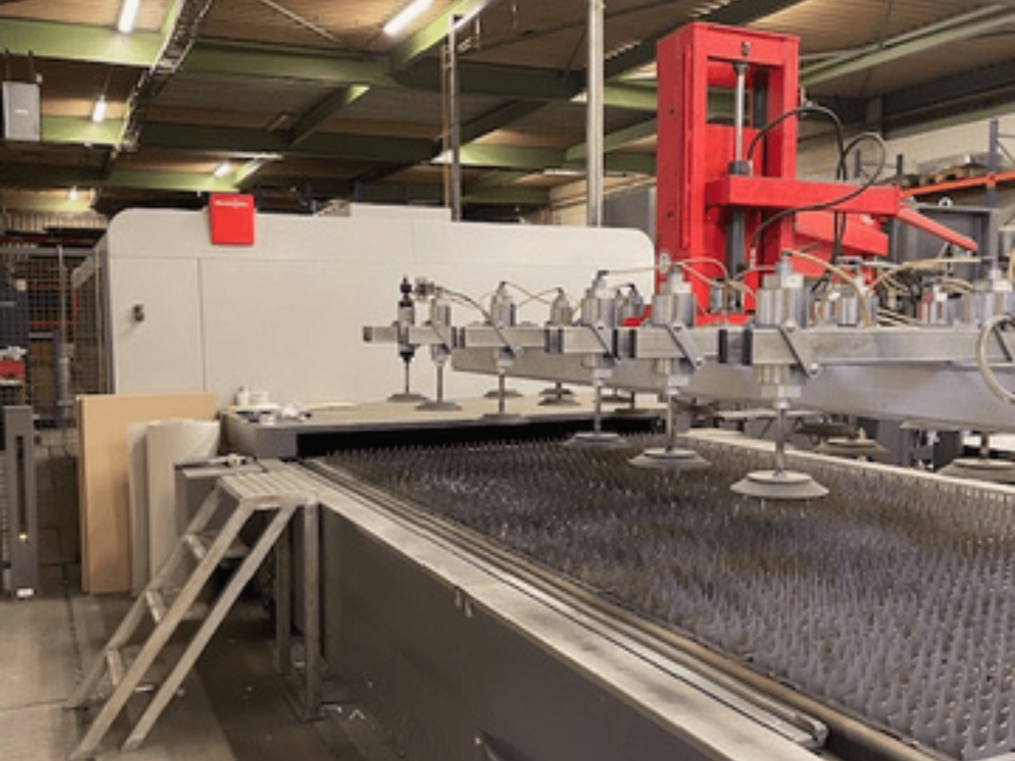 Bystronic BySprint Fiber 4020 Fiber 4Kw šķiedras lāzera griešanas mašīnas priekšējais skats ar sprauslām un griešanas gultni.