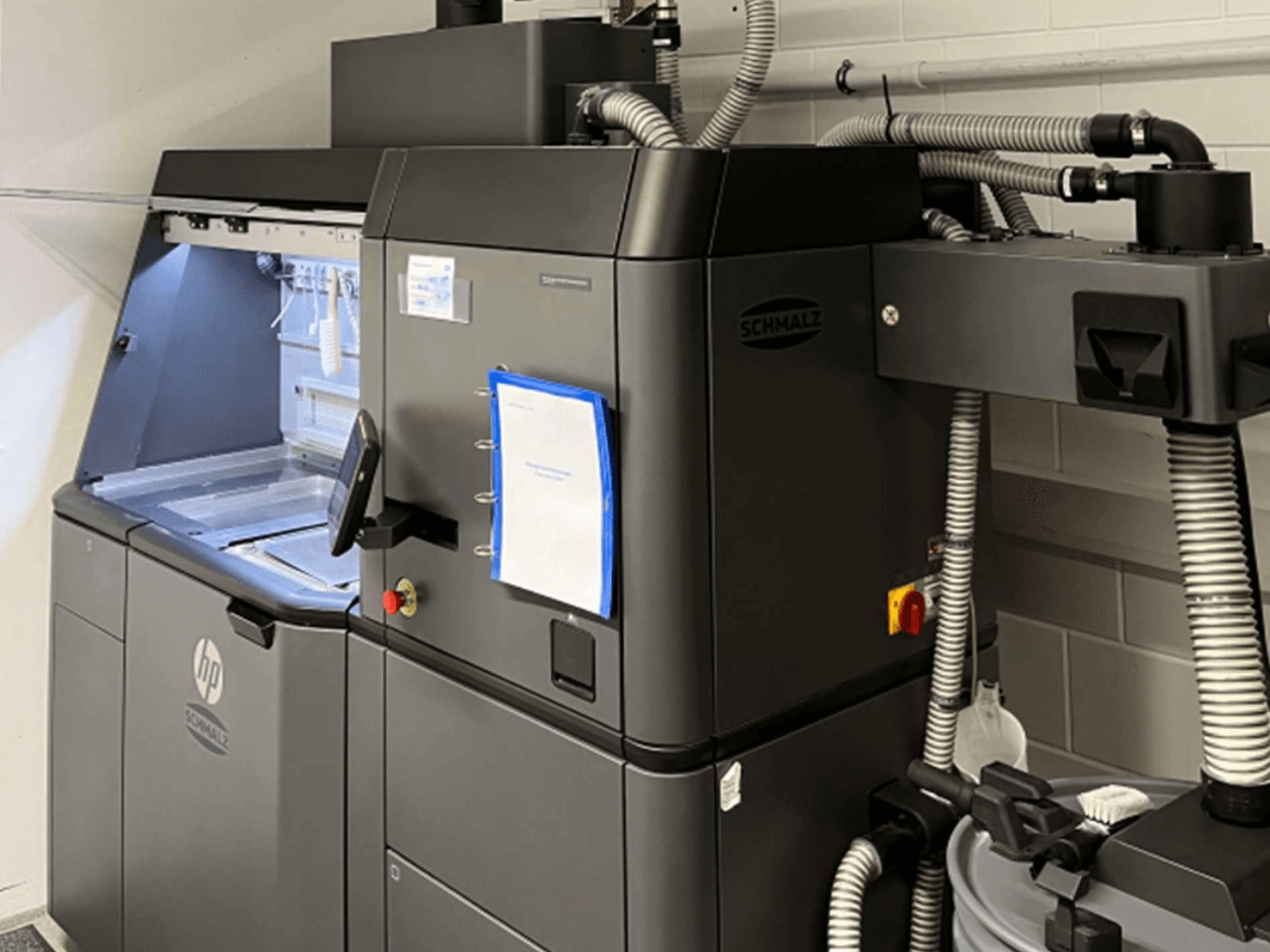 HP Jet Fusion 3D 4200 plastmasas 3D printeris, skats no sāniem, kurā redzams vadības panelis un iekšējās detaļas.